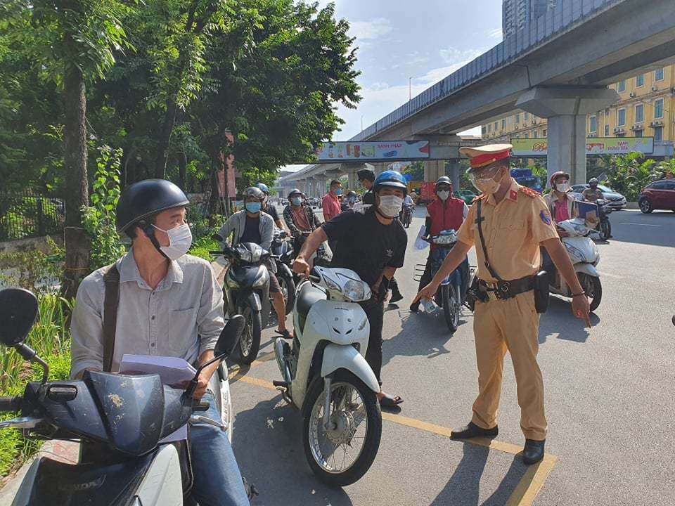 Chốt kiểm soát trên đường Nguyễn Trãi qua địa bàn quận Thanh Xuân (Hà Nội), Tổ công tác phối hợp tiến hành chia làm 3 làn, chia ra làm 2 điểm, điểm 1 CSGT hướng dẫn phương tiện cho người điều khiển đi chậm đúng vào làn đường, đồng thời cảnh sát cơ động nhắc nhở mọi người điều khiển qua chốt cầm sẵn giấy đi đường để tổ công tác kiểm tra.