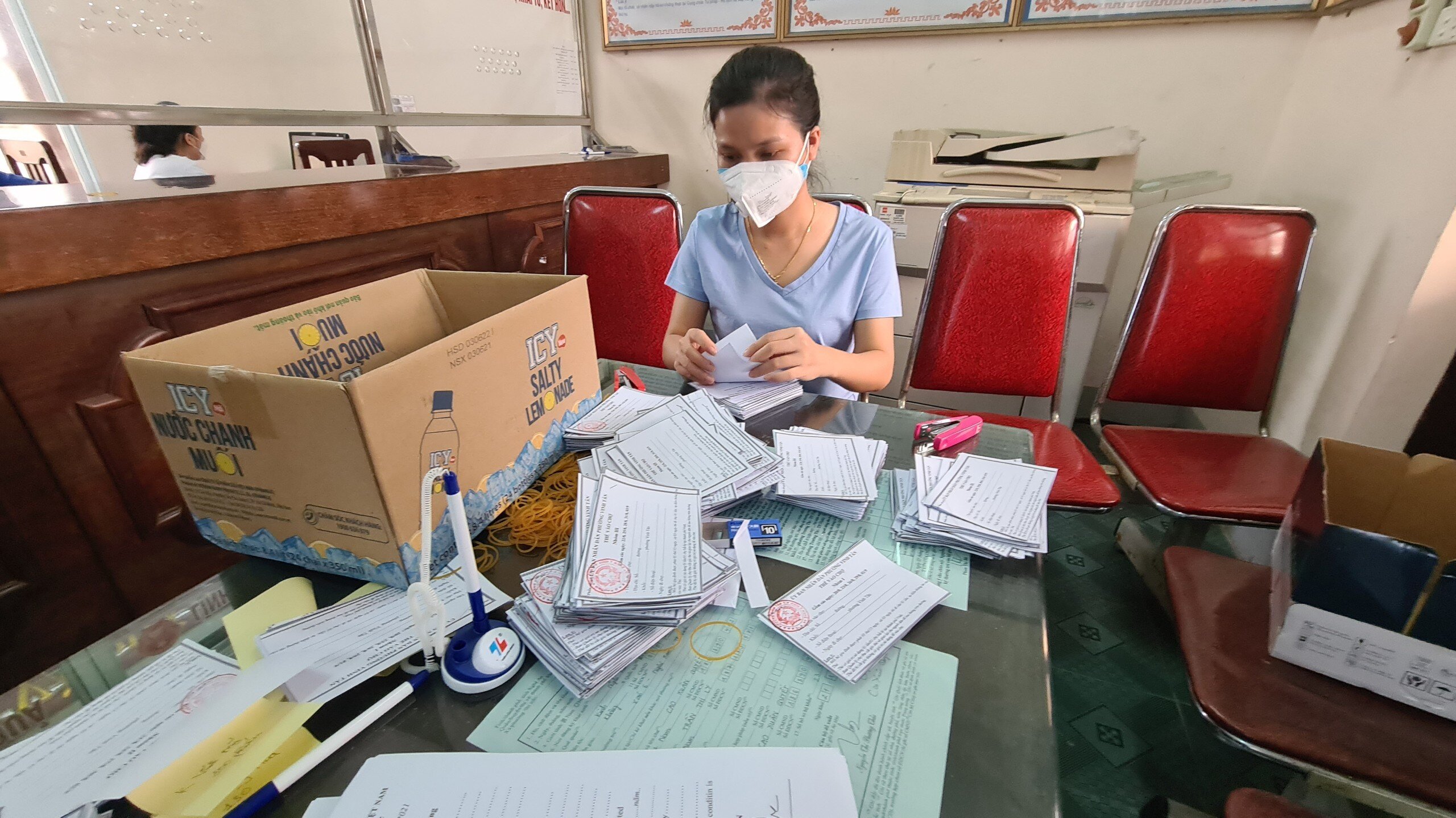 Phiếu được đếm thủ công từng tờ, rồi ghim lại thành cặp 5 tờ để phát cho các hộ dân dùng đi chợ trong 15 ngày giãn cách xã hội.