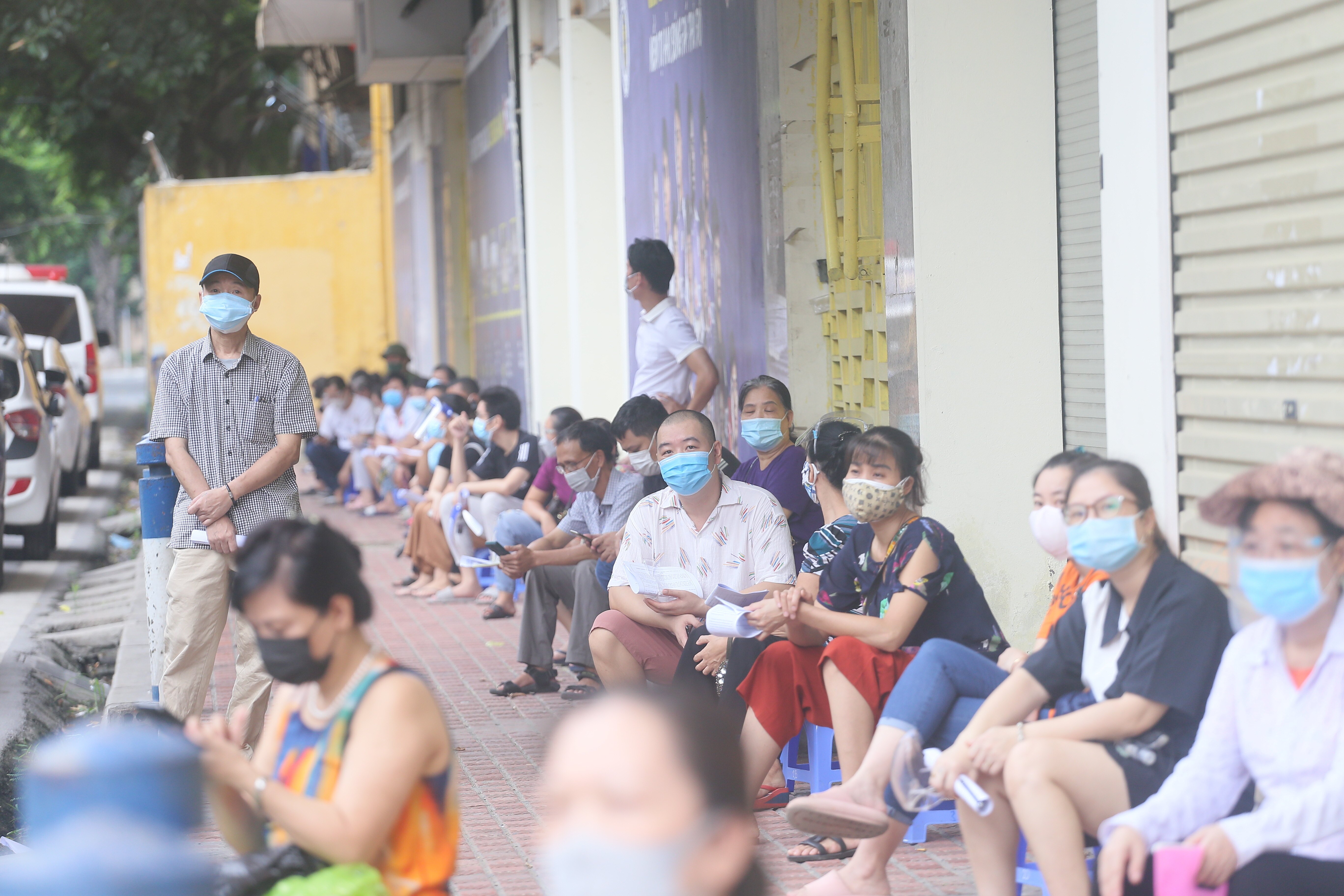 Trước khi đến lượt l&agrave;m thủ tục ti&ecirc;m vaccine, người d&acirc;n đến đ&acirc;y được hướng dẫn xếp h&agrave;ng gi&atilde;n c&aacute;ch theo đ&uacute;ng quy định ph&ograve;ng chống dịch.