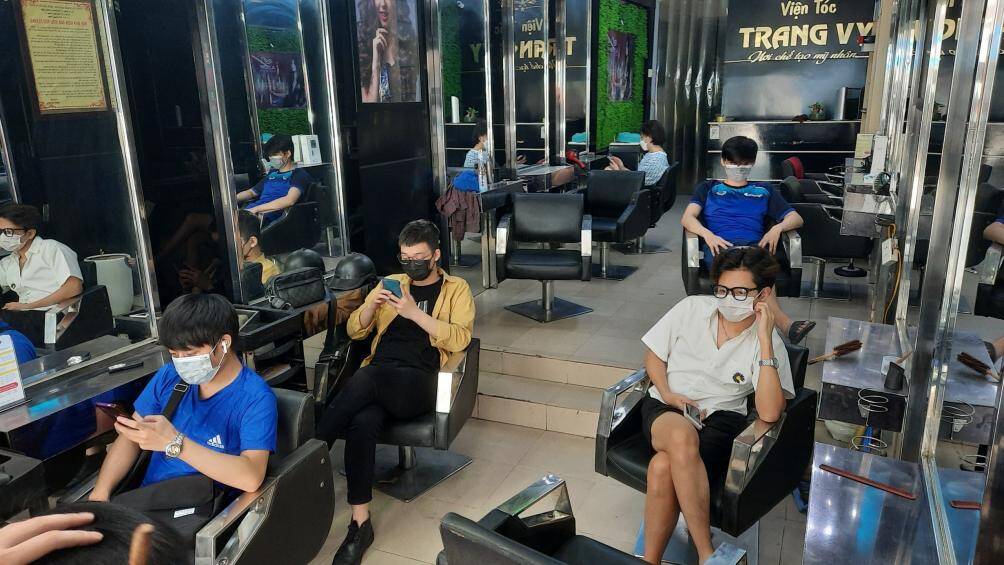 Một cửa h&agrave;ng tr&ecirc;n phố Dương Quảng H&agrave;m (Cầu Giấy) d&ugrave; mở cửa từ rất sớm nhưng đ&atilde; c&oacute; kh&aacute; đ&ocirc;ng người xếp h&agrave;ng chờ đến lượt để cắt t&oacute;c.