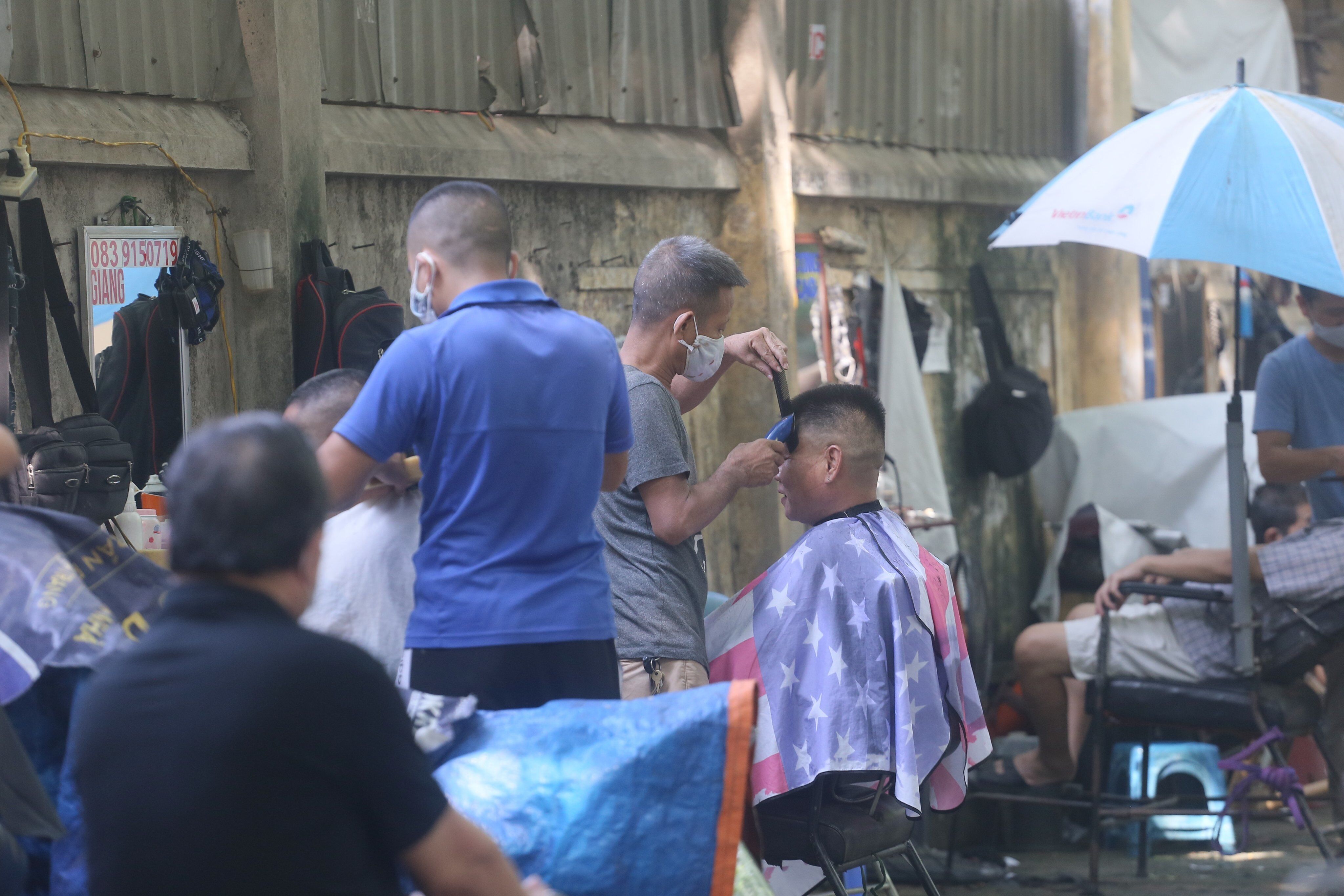 H&agrave;ng loạt "salon t&oacute;c" vỉa h&egrave; phố Th&aacute;i Thịnh cũng hoạt động hết c&ocirc;ng suất từ 6h s&aacute;ng.