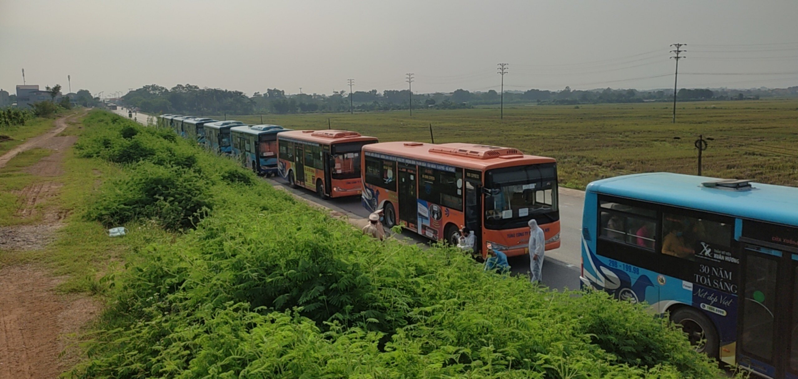 H&agrave;ng chục xe bu&yacute;t tập kết tại chốt kiểm so&aacute;t số 1 cửa ng&otilde; ra v&agrave;o H&agrave; Nội (Ph&aacute;p V&acirc;n - Cầu Giẽ) đ&oacute;n người d&acirc;n về c&aacute;c tỉnh.