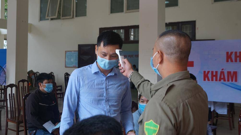 Trước khi v&agrave;o khu vực ti&ecirc;m, người d&acirc;n đều được kiểm tra th&acirc;n nhiệt.
