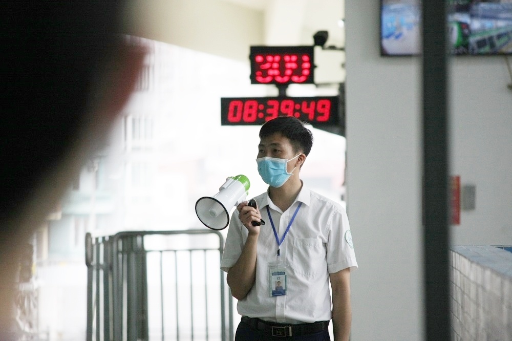 Một số nh&acirc;n vi&ecirc;n kh&aacute;c li&ecirc;n tục d&ugrave;ng loa cầm tay hướng dẫn người d&acirc;n hướng di chuyển ra, v&agrave;o nh&agrave; ga v&agrave; khu vực chờ t&agrave;u.