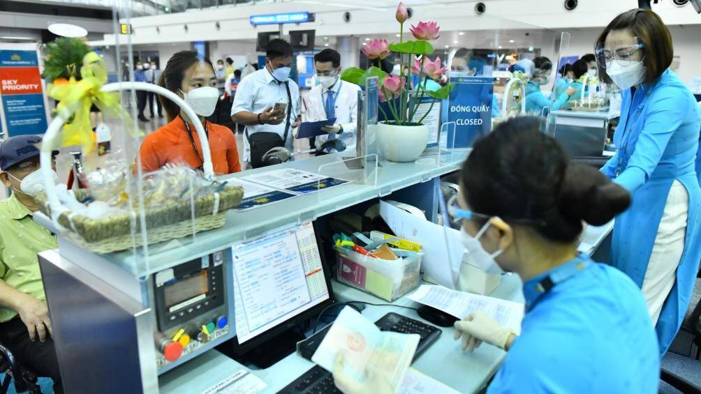 H&agrave;nh kh&aacute;ch l&agrave;m thủ tục v&agrave; di chuyển l&ecirc;n t&agrave;u bay.