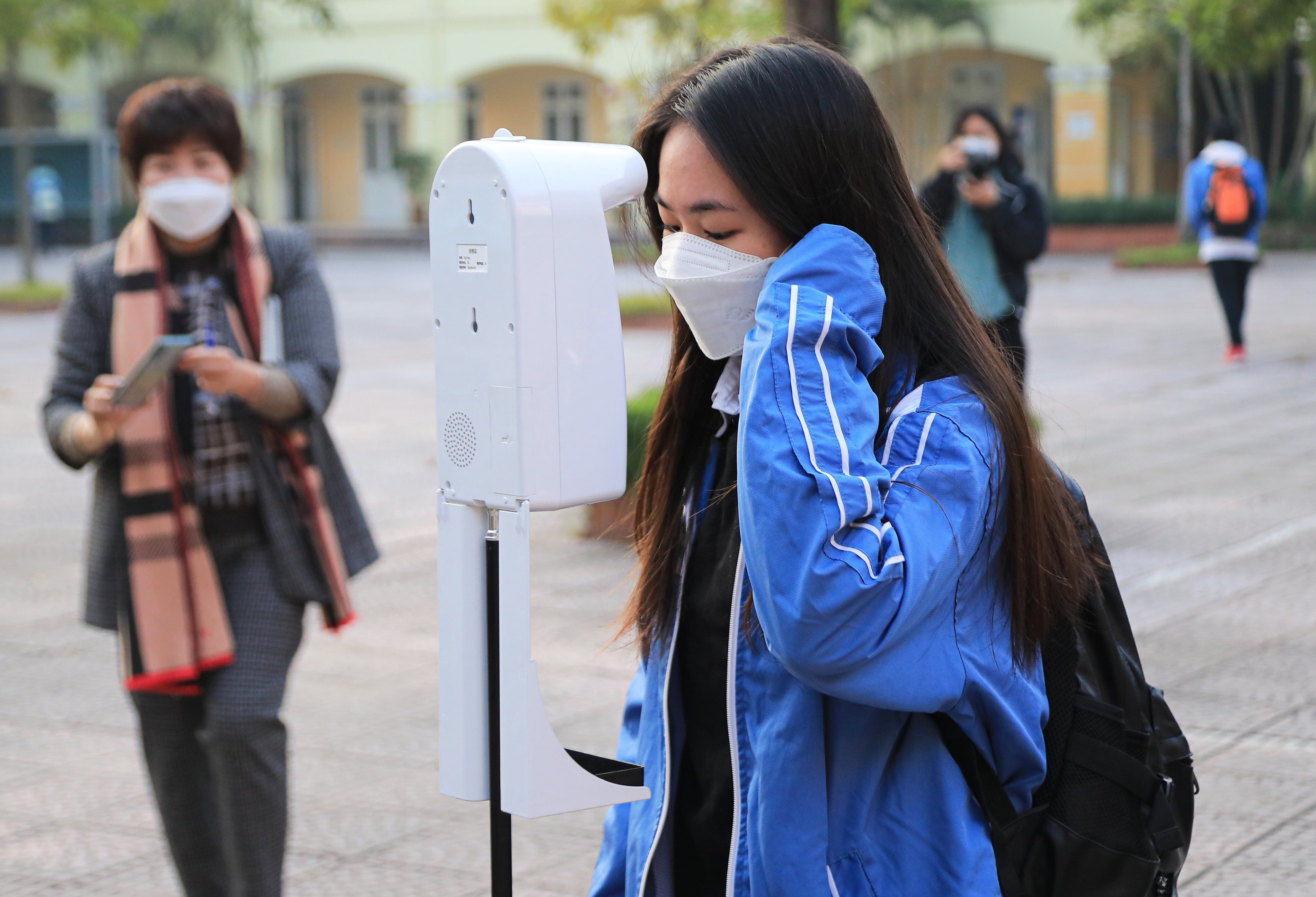 Trước khi v&agrave;o trường, c&aacute;c em học sinh được y&ecirc;u cầu s&aacute;t khuẩn tay v&agrave; đo nhiệt độ