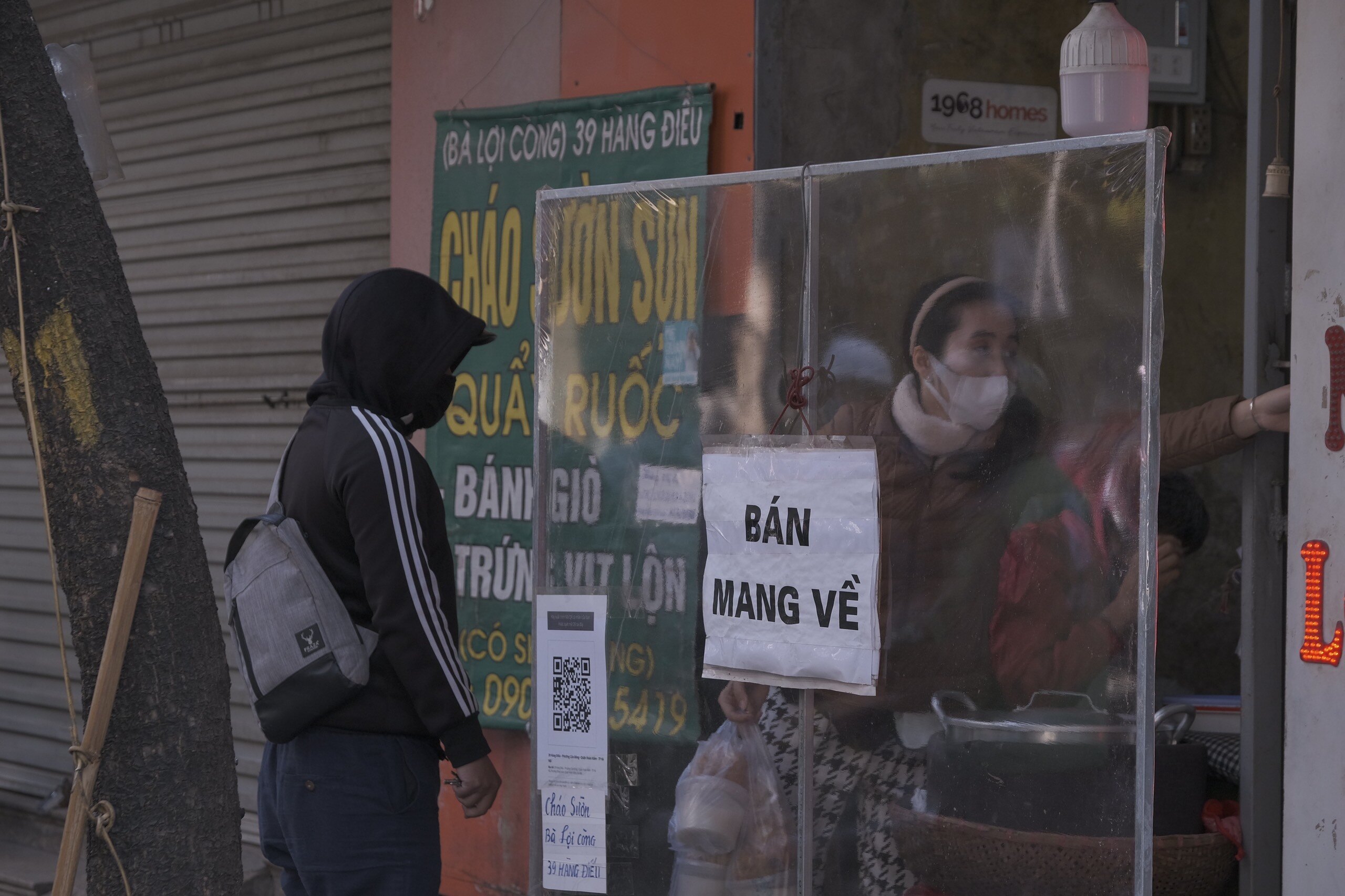 Tại qu&aacute;n ch&aacute;o sườn tr&ecirc;n phố H&agrave;ng Điếu, quận Ho&agrave;n Kiếm, H&agrave; Nội đặt th&ocirc;ng b&aacute;o chỉ b&aacute;n h&agrave;ng mang về,kh&aacute;ch đến mua h&agrave;ng được nhắc nhở qu&eacute;t m&atilde; QR.