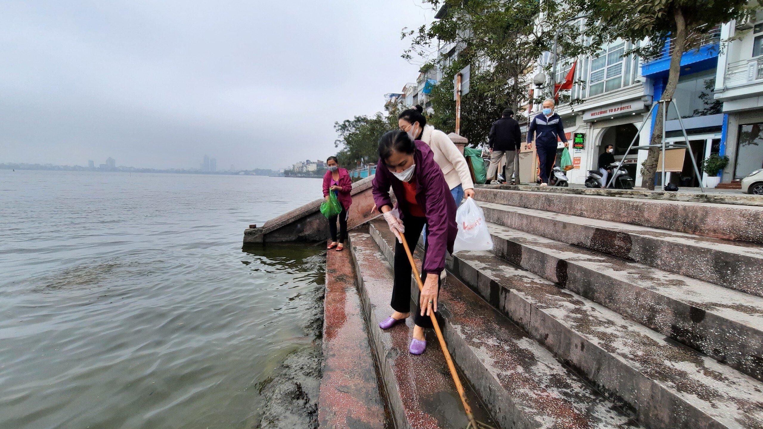 Để gi&uacute;p người d&acirc;n thả c&aacute; ch&eacute;p an to&agrave;n, Hội Li&ecirc;n hiệp Phụ nữ phường Thụy Khu&ecirc; (quận T&acirc;y Hồ) cử người thường xuy&ecirc;n qu&eacute;t dọn cầu thang l&ecirc;n xuống để người d&acirc;n xuống thả c&aacute; kh&ocirc;ng bị trơn trượt.