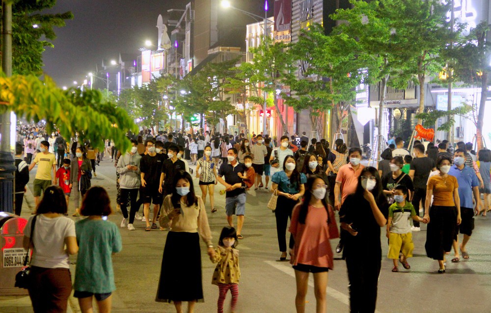 Mọi người nắm tay nhau đi dạo phố nhưng vẫn chấp h&agrave;nh nghi&ecirc;m t&uacute;c việc đeo khẩu trang ph&ograve;ng dịch.