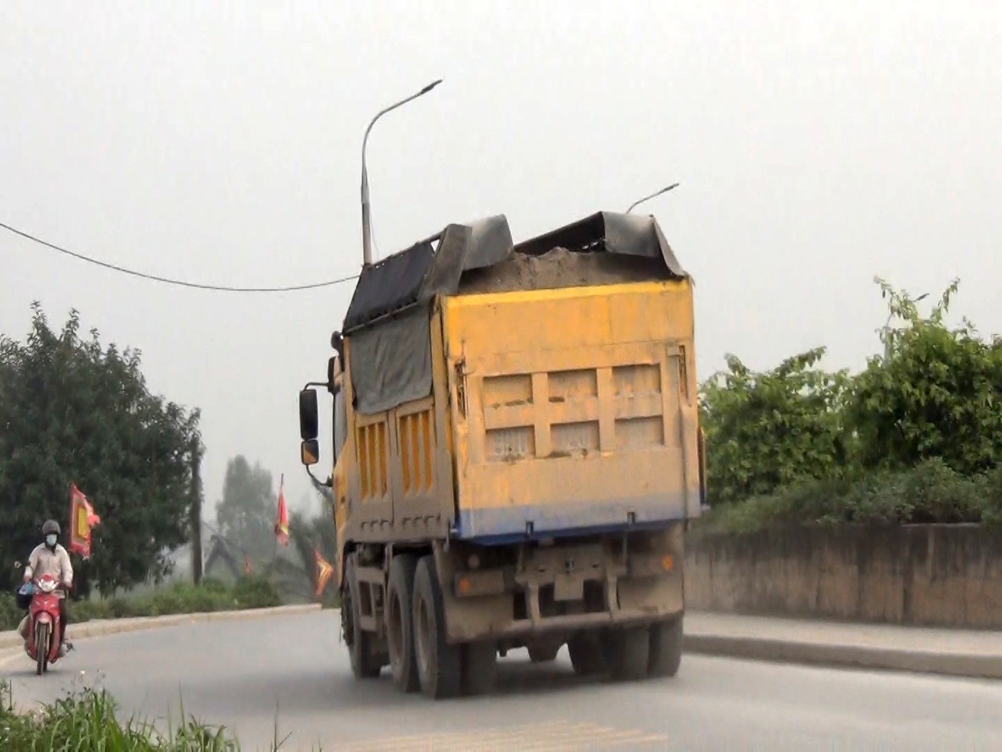 Nhiều xe chở c&aacute;t chất cao ch&oacute;t v&oacute;t n&ecirc;n chỉ cần gi&oacute; cũng l&agrave;m c&aacute;t bay xuống đường.