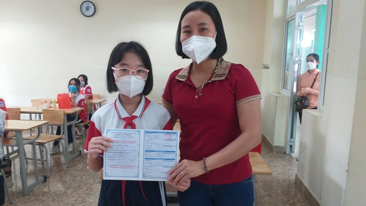 Cầm tờ chứng ti&ecirc;m chủng mũi 1 cho con g&aacute;i Nguyễn Tuệ Phương, học sinh lớp 6A2, chị Nguyễn Thị Thu Nga nh&agrave; ở khu 4, phường Hồng H&agrave;, TP Hạ Long phấn khởi khoe: "Trong đợt dịch Covid -19 n&agrave;y, vợ, chồng em lo nhất l&agrave; c&aacute;c con nhỏ chưa được ti&ecirc;m chủng. Nay cho con đi ti&ecirc;m, thấy sức khỏe của ch&aacute;u b&igrave;nh thường sau ti&ecirc;m, em mừng lắm. Phụ huynh ch&uacute;ng em rất cảm ơn sự chăm lo cho trẻ em của c&aacute;c ng&agrave;nh, c&aacute;c cấp".