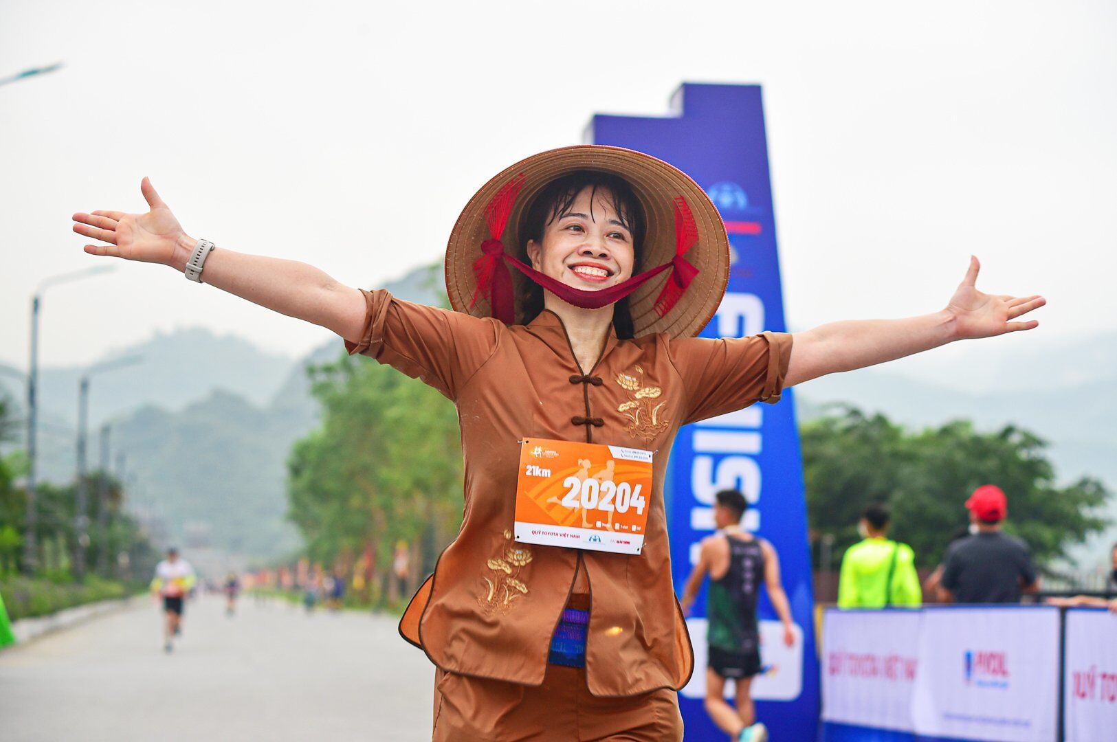 Một vận động vi&ecirc;n tham gia cự ly 21km với chiếc n&oacute;n l&aacute; đội tr&ecirc;n đầu để lại nhiều ấn tượng cho c&aacute;c cổ động vi&ecirc;n.