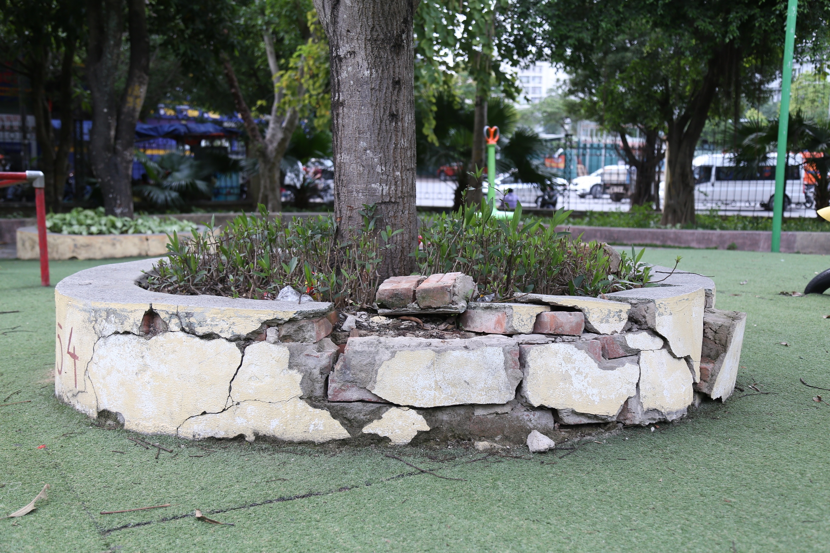 Nhiều bồn c&acirc;y tại C&ocirc;ng vi&ecirc;n Cầu Giấy cũng bị vỡ n&aacute;t, được xếp gạch tạm bợ n&ecirc;n trẻ con chỉ cần chạy l&ecirc;n l&agrave; đổ.