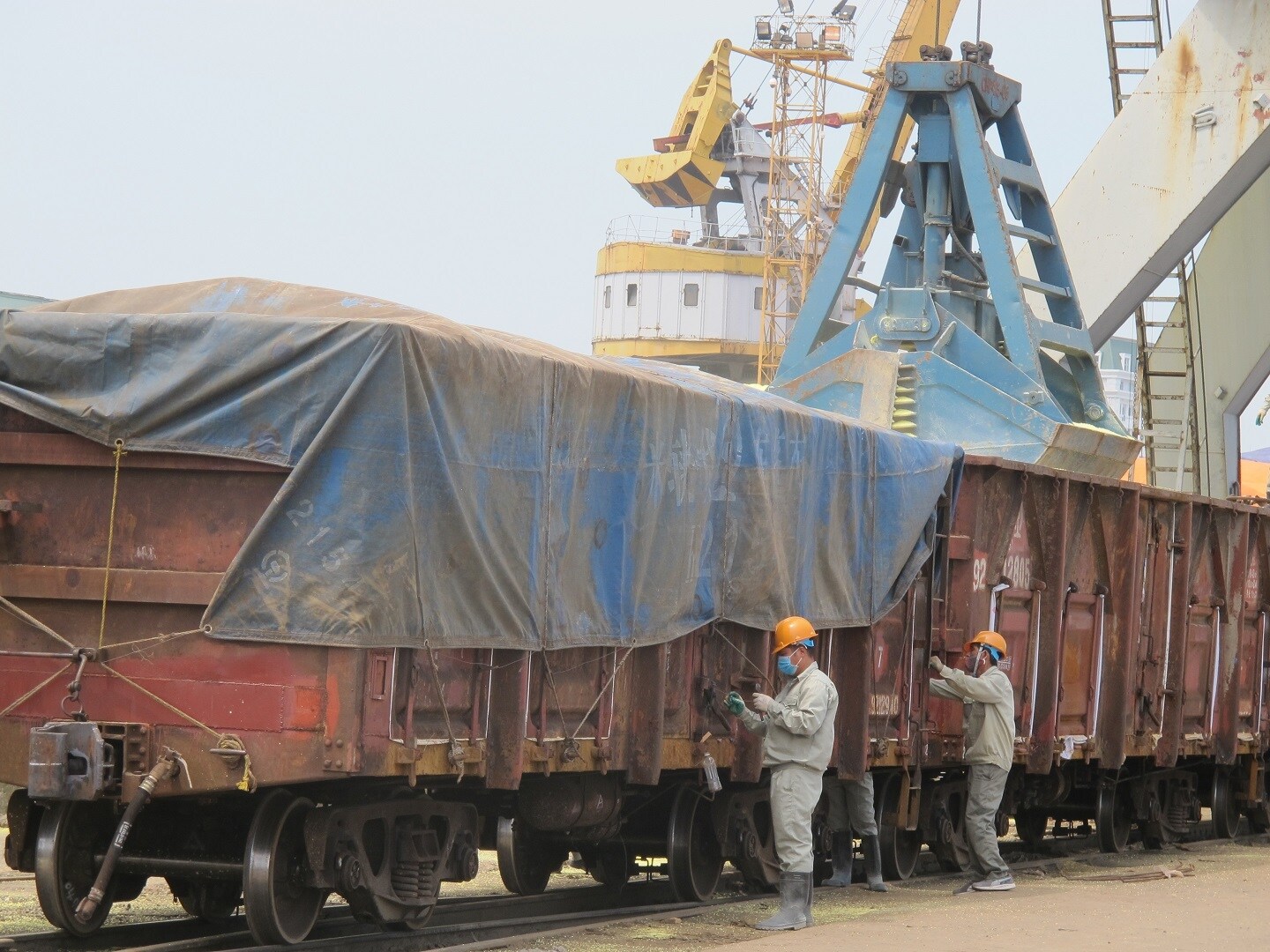 To&agrave;n bộ h&agrave;ng h&oacute;a tổ chức xếp dỡ, chuyển tải tại khu vực ga cảng v&agrave; cầu cảng. Gi&aacute;m s&aacute;t hải quan đối với phương tiện vận tải v&agrave; l&agrave;m thủ tục hải quan đối với h&agrave;ng h&oacute;a xuất nhập khẩu. H&agrave;ng h&oacute;a sau khi được xếp l&ecirc;n toa xe sẽ được phủ bạt, ni&ecirc;m phong, l&agrave;m thủ tục hải quan v&agrave; chạy thẳng ga L&agrave;o Cai. Tại ga L&agrave;o Cai sẽ chỉ l&agrave;m thủ tục th&ocirc;ng quan, kh&ocirc;ng phải kiểm h&oacute;a, toa xe giữ nguy&ecirc;n ni&ecirc;m phong được k&eacute;o sang ga Sơn Y&ecirc;u. 
Ảnh: C&ocirc;ng nh&acirc;n phủ bạt, gia cố, ni&ecirc;m phong toa xe h&agrave;ng sau khi xếp tại cảng Hải Ph&ograve;ng