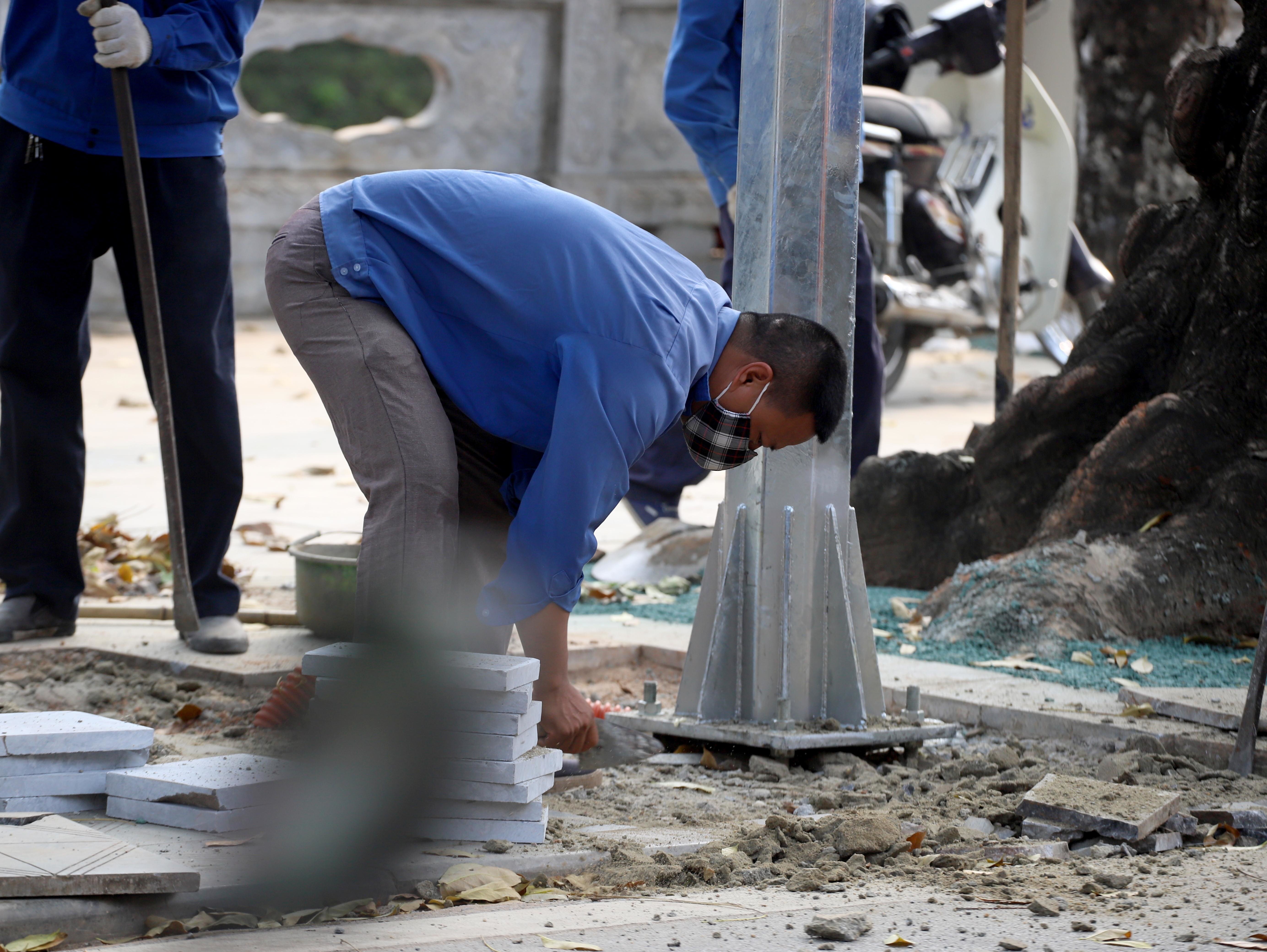 C&aacute;c c&ocirc;ng nh&acirc;n đang lắp những cột đền trang tr&iacute; tại đường Ph&oacute; Đức Ch&iacute;nh.