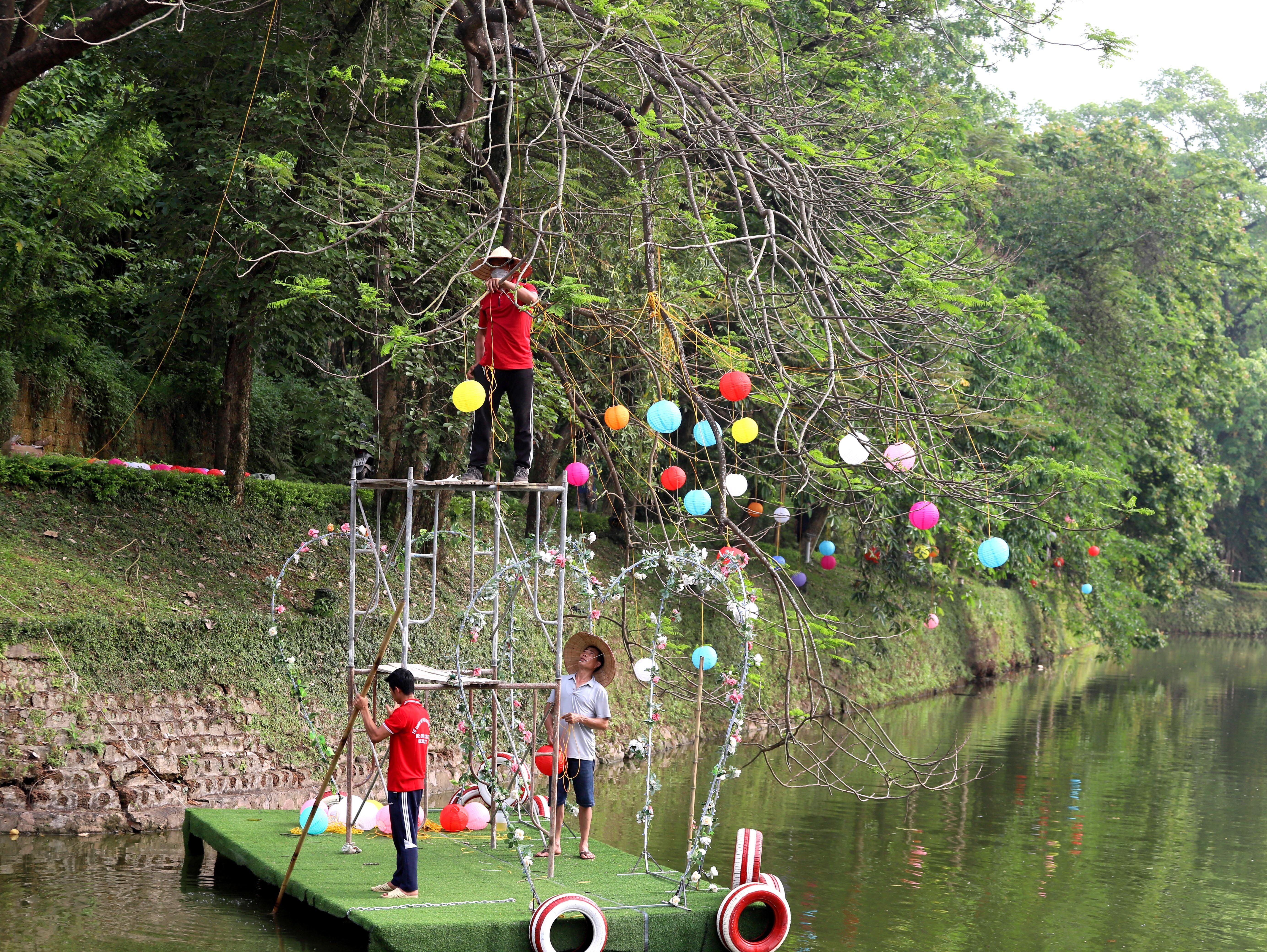 Đ&egrave;n trang tr&iacute; ở khu vực hồ quanh Th&agrave;nh cổ Sơn T&acirc;y cũng đang được c&aacute;c c&ocirc;ng nh&acirc;n gấp r&uacute;t treo l&ecirc;n c&aacute;c c&agrave;nh c&acirc;y.