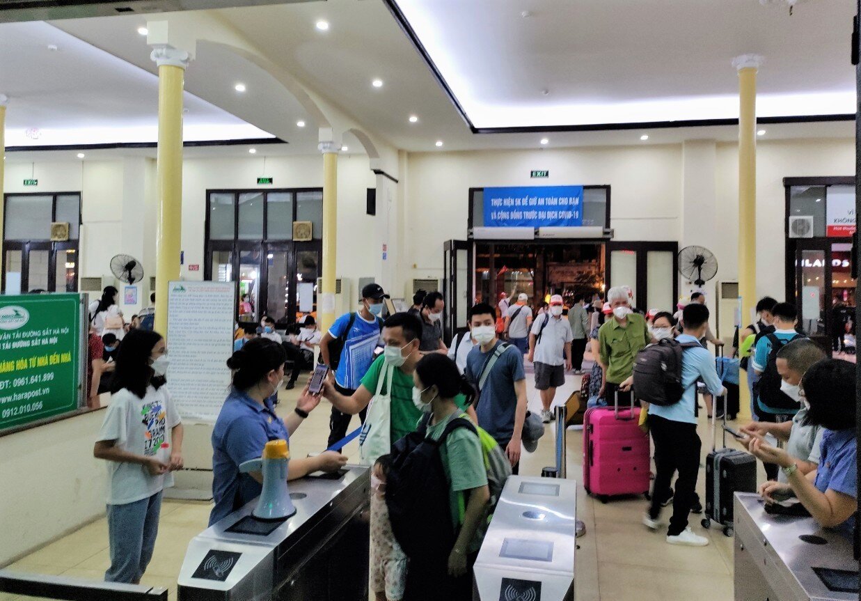 Tuy nhiều chuyến nhưng do gi&atilde;n c&aacute;ch giữa c&aacute;c chuyến xa, nh&agrave; ga mở nhiều cửa đ&oacute;n kh&aacute;ch, nhiều ph&ograve;ng đợi t&agrave;u n&ecirc;n kh&ocirc;ng bị &ugrave;n ứ. Ảnh: Nh&acirc;n vi&ecirc;n kiểm so&aacute;t v&eacute; h&agrave;nh kh&aacute;ch trước khi v&agrave;o ga.