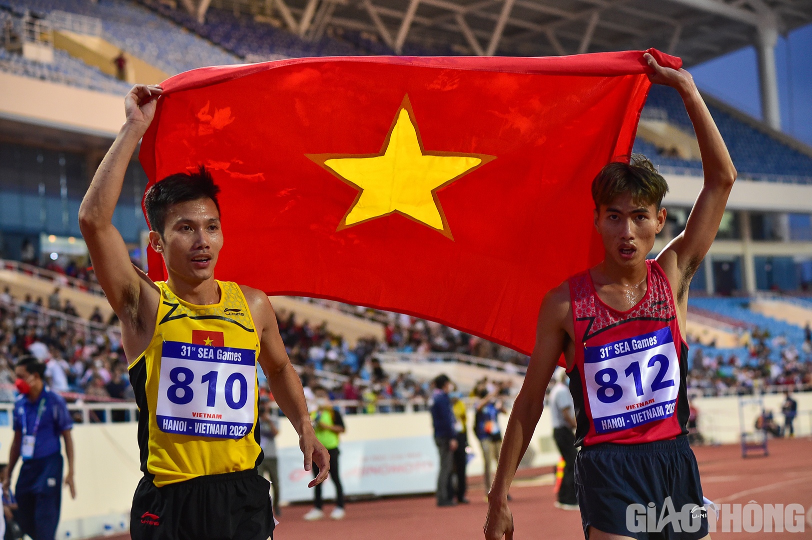 Tiến Long v&agrave; Quốc Luật giương cao l&aacute; cờ Tổ quốc chạy xung quanh kh&aacute;n đ&agrave;i v&agrave; chia vui với c&aacute;c kh&aacute;n giả c&oacute; mặt tr&ecirc;n s&acirc;n.