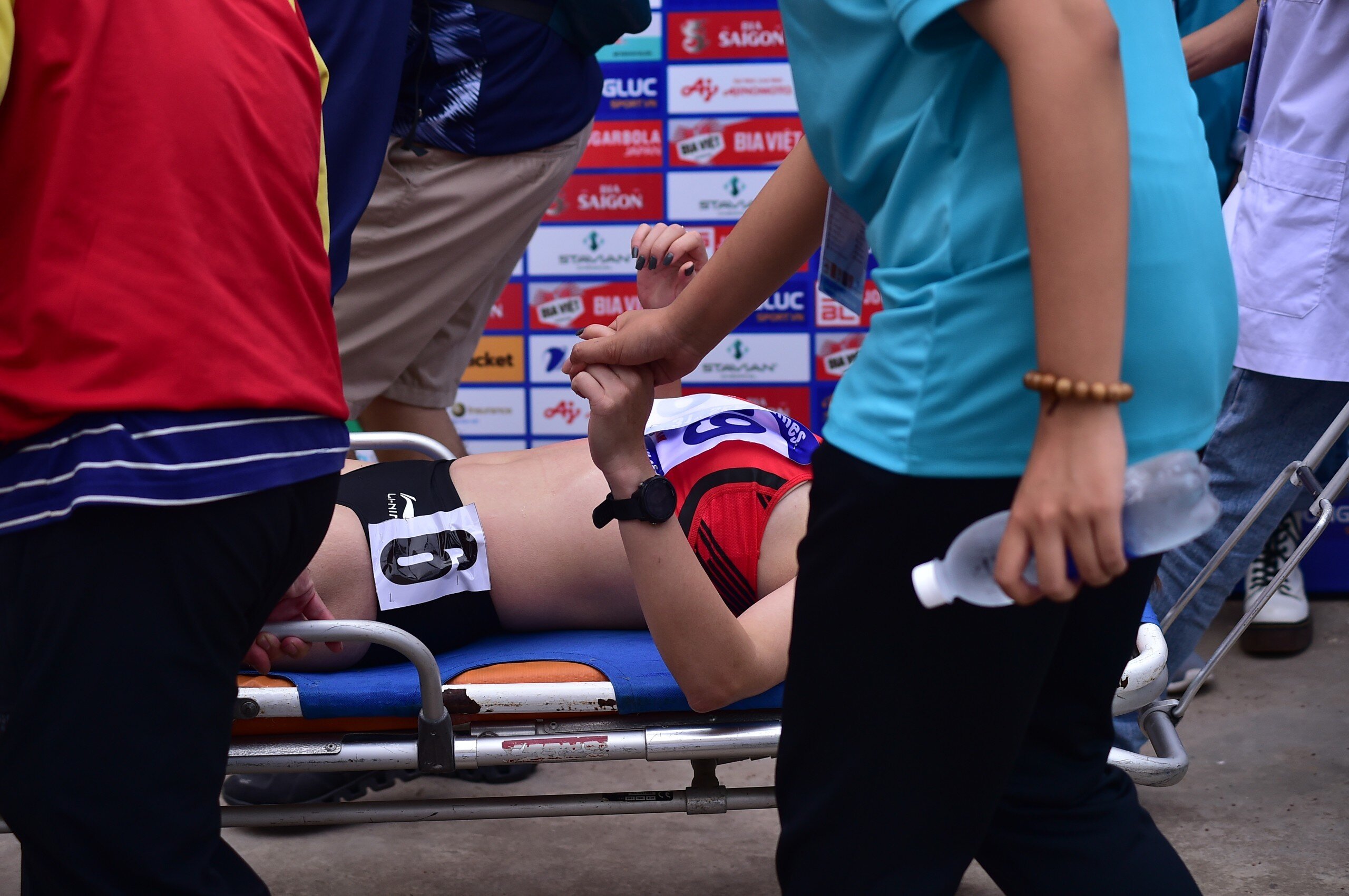Nh&agrave; v&ocirc; địch SEA Games 30 nắm chặt tay một t&igrave;nh nguyện vi&ecirc;n. C&ocirc; kh&ocirc;ng những kh&ocirc;ng thể bảo vệ tấm HCV m&agrave; c&ograve;n d&iacute;nh chấn thương.