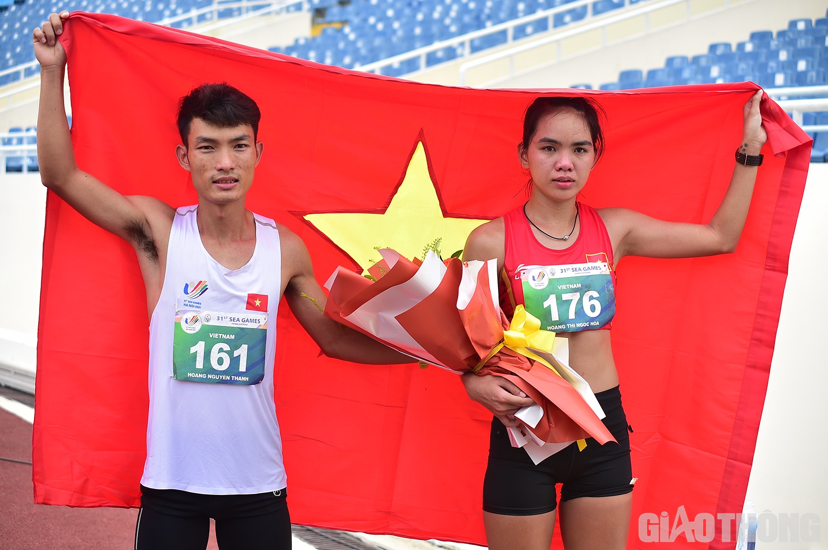 Ho&agrave;ng Nguy&ecirc;n Thanh, nh&agrave; v&ocirc; địch nội dung marathon nam, &ocirc;m hoa đến tặng v&agrave; kho&aacute;c cờ Tổ quốc động vi&ecirc;n Ho&agrave;ng Thị Ngọc Hoa. Cả 2 đều l&agrave; c&aacute;c VĐV của B&igrave;nh Phước, c&ugrave;ng v&ocirc; địch Tiền Phong marathon 2022 trước khi tham dự SEA Games 31.