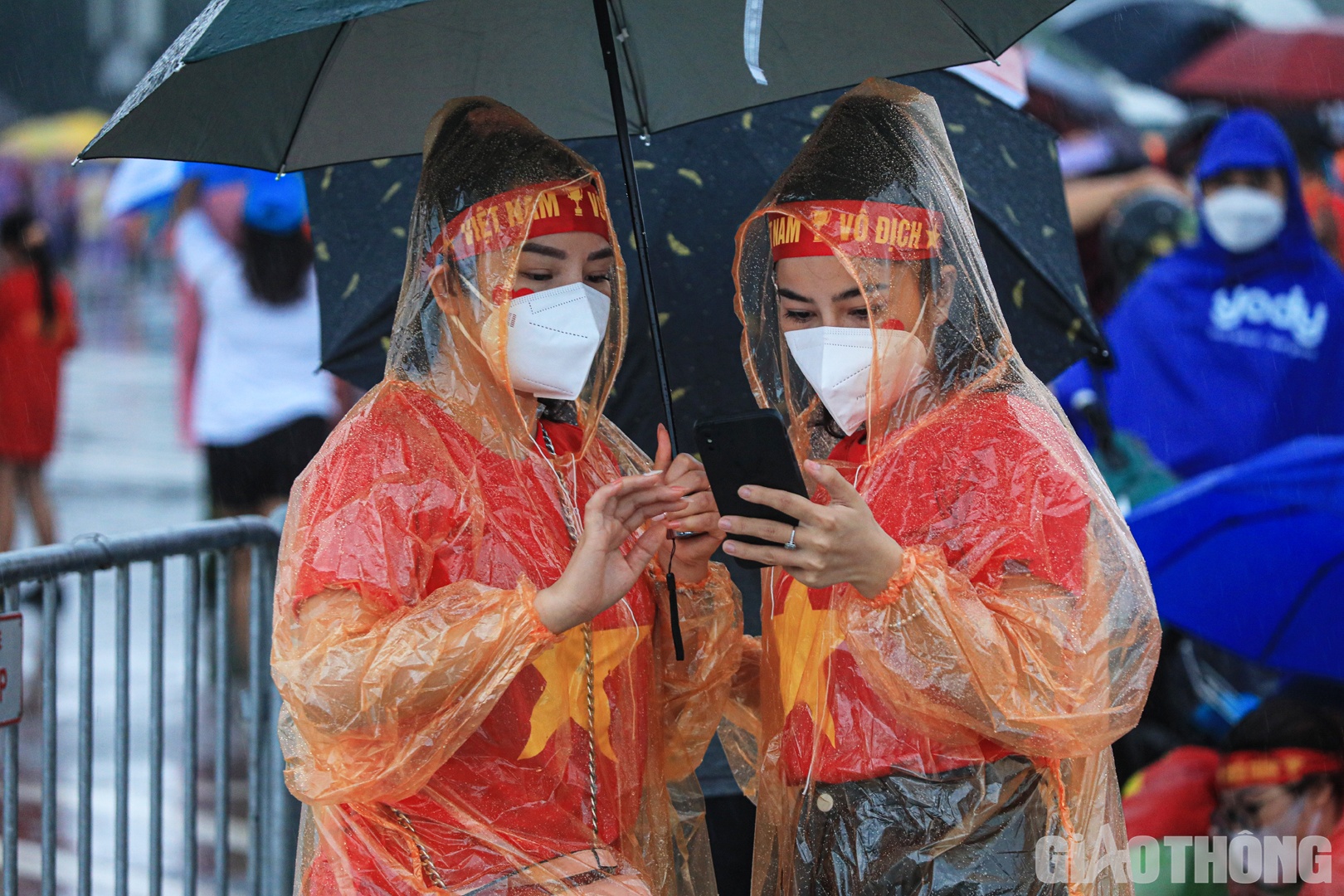 CĐV mặc &aacute;o đỏ sao v&agrave;ng "đội mưa" trước trận cầu hấp dẫn.