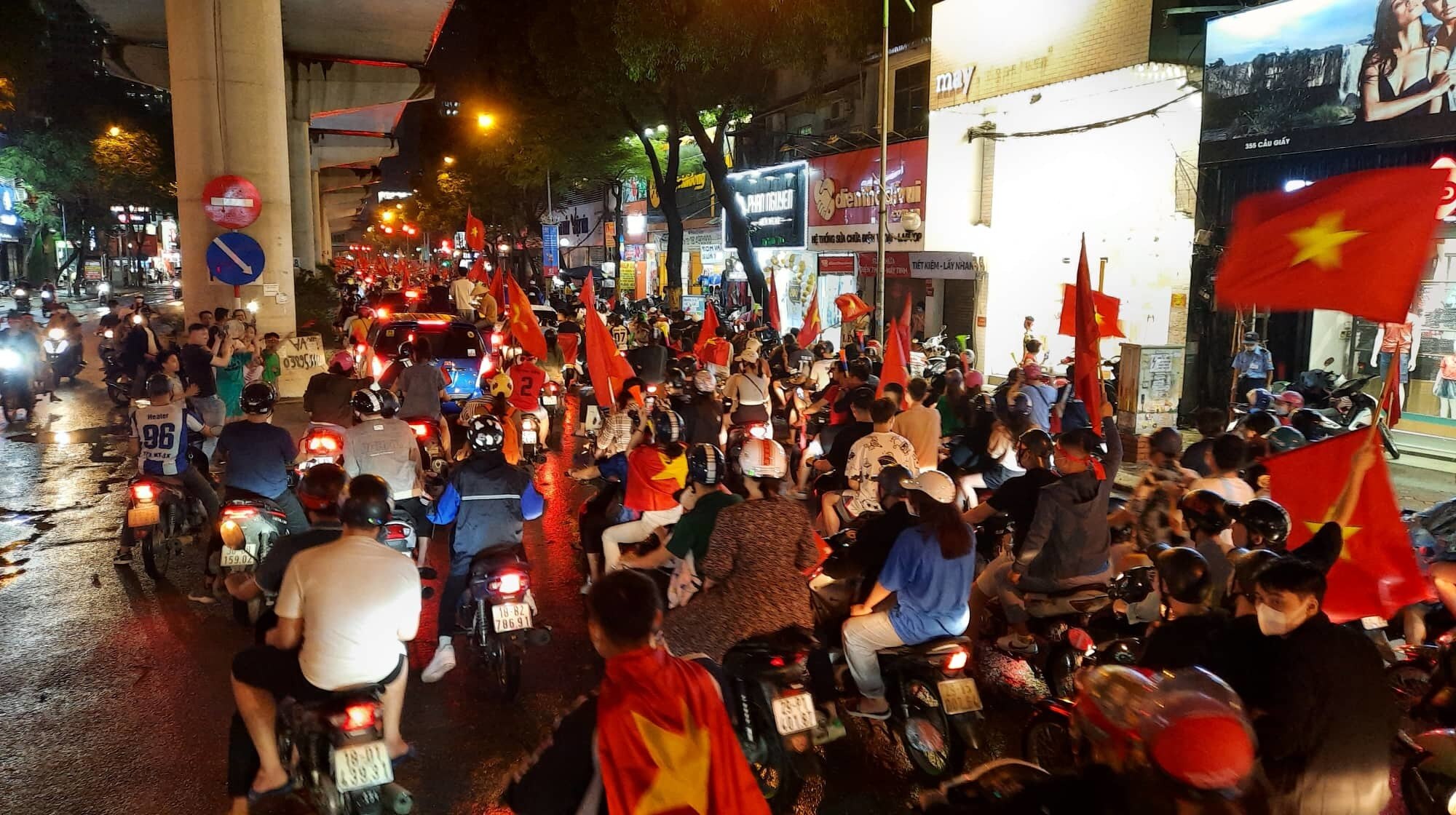 Phố Cầu Giấy (TP H&agrave; Nội) h&agrave;ng chục ngh&igrave;n cổ động vi&ecirc;n đ&atilde; n&ecirc;m k&iacute;n đường bằng cờ đỏ sao v&agrave;ng.