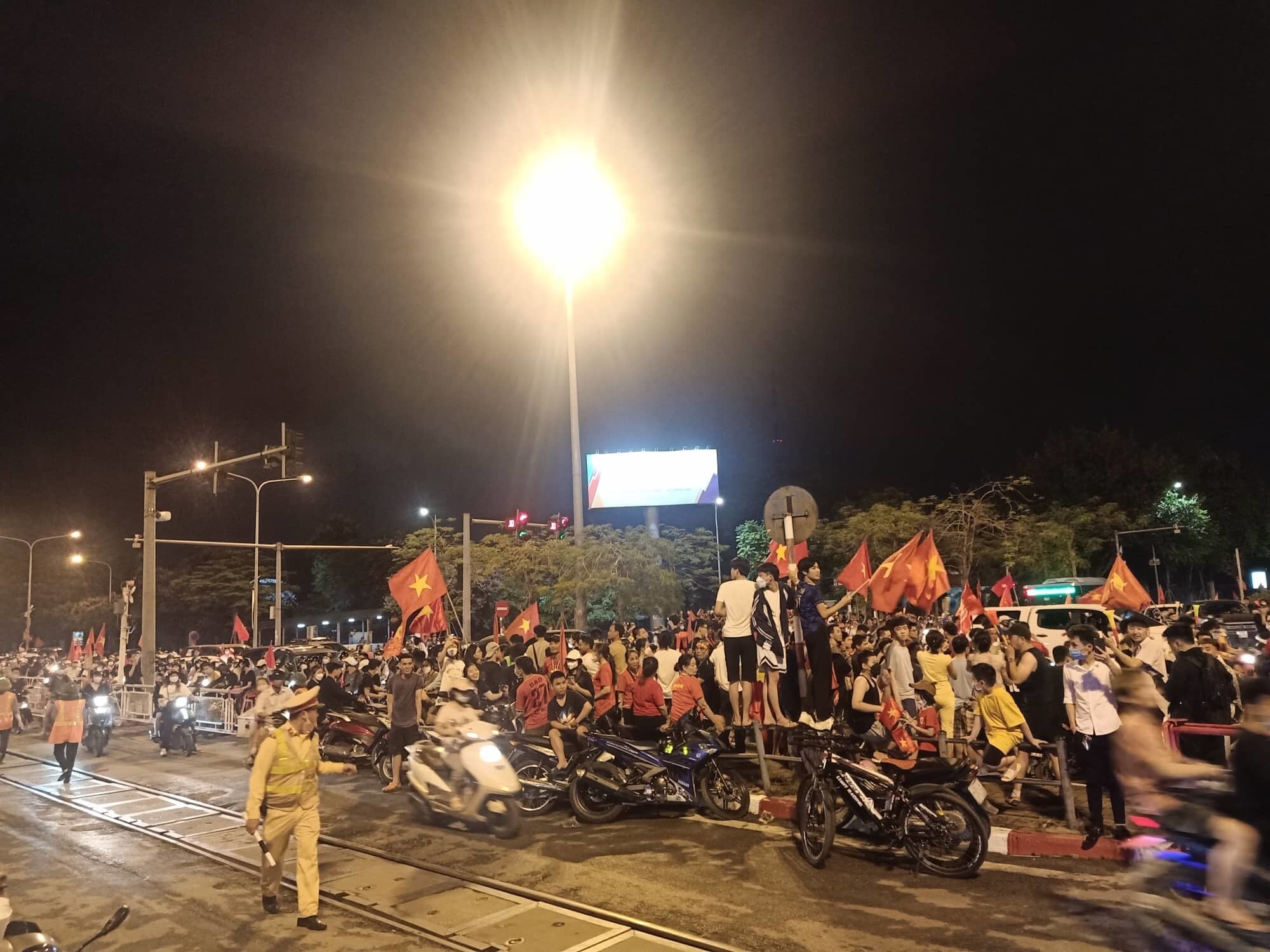 Ng&atilde; tư Giải Ph&oacute;ng - L&ecirc; Duẩn h&agrave;ng chục ngh&igrave;n cổ động vi&ecirc;n cũng đổ ra ăn mừng chiến t&iacute;ch bảo vệ th&agrave;nh c&ocirc;ng tấm HCV Sea Game của tuyển nam Việt Nam.