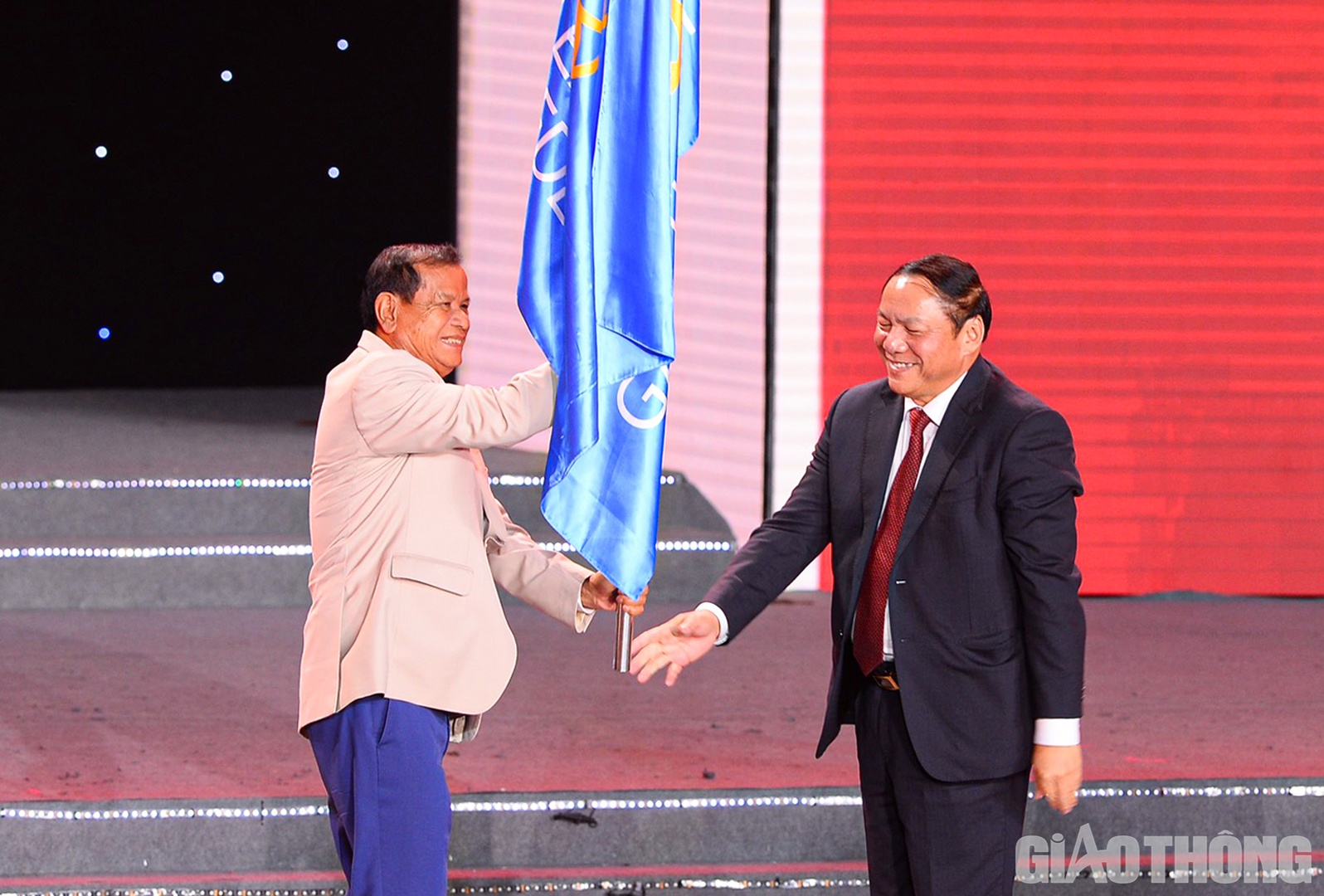 Bộ trưởng Bộ Văn h&oacute;a Thể thao v&agrave; Du lịch Nguyễn Văn H&ugrave;ng trao cờ Li&ecirc;n đo&agrave;n thể thao Đ&ocirc;ng Nam &Aacute; từ chủ nh&agrave; Việt Nam cho đại diện Ủy ban Olympic Campuchia - nước chủ nh&agrave; SEA Games 32.