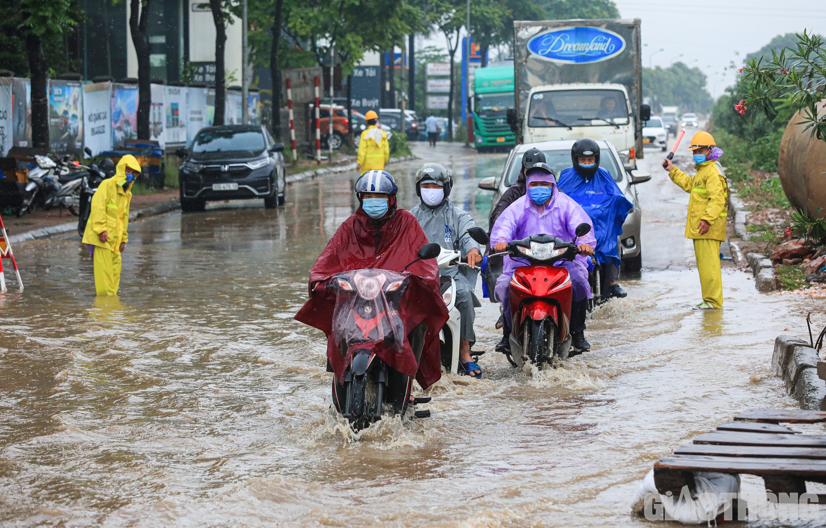 C&aacute;c nh&acirc;n vi&ecirc;n c&ocirc;ng ty tho&aacute;t nước t&uacute;c trực, hỗ trợ người d&acirc;n đi qua điểm ngập nước.