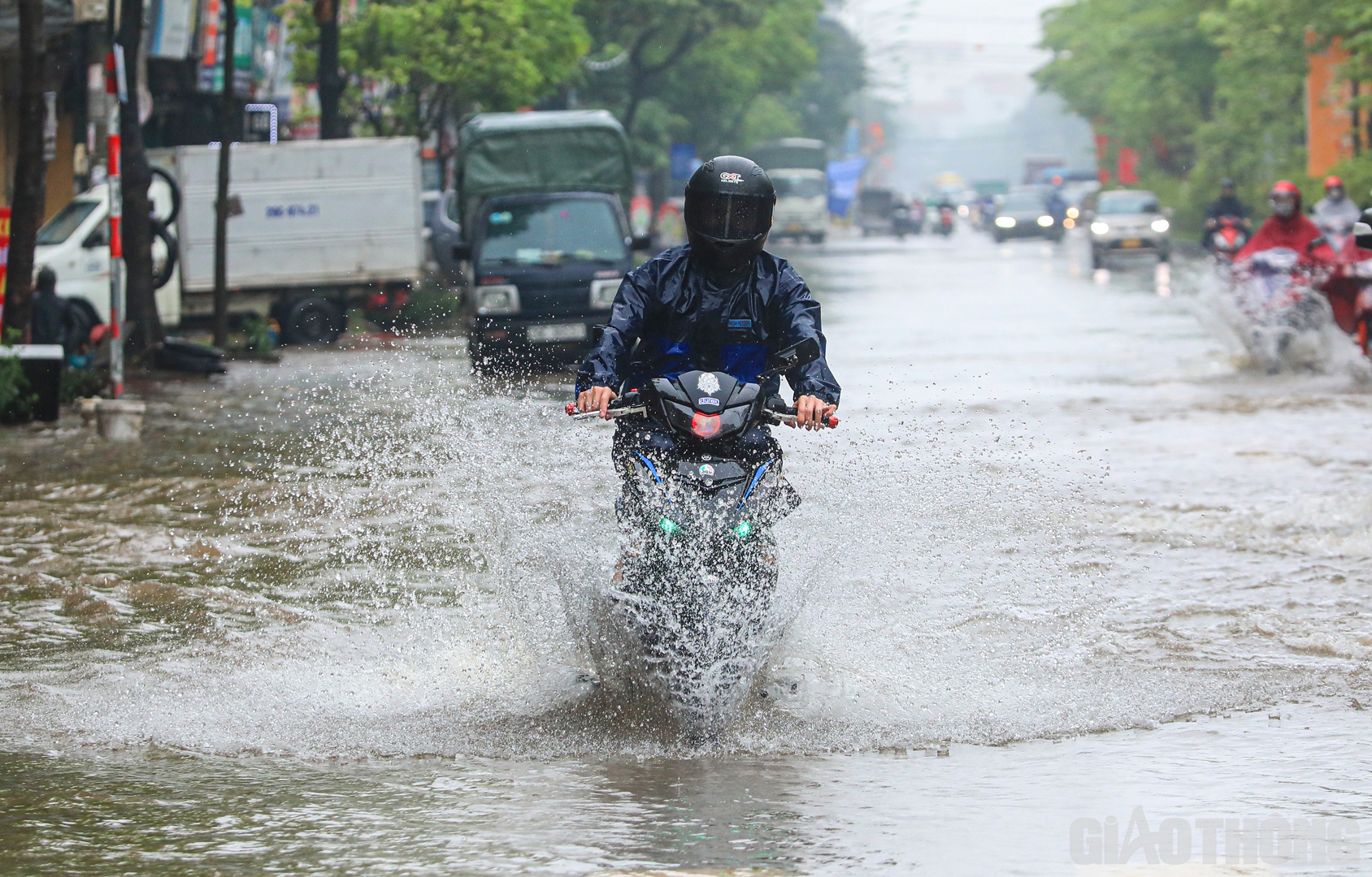 H&igrave;nh ảnh người d&acirc;n "rẽ s&oacute;ng" băng qua đoạn đường ngập.