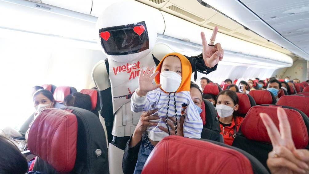 Một h&agrave;nh kh&aacute;ch nh&iacute; chụp ảnh kỷ niệm c&ugrave;ng robot.