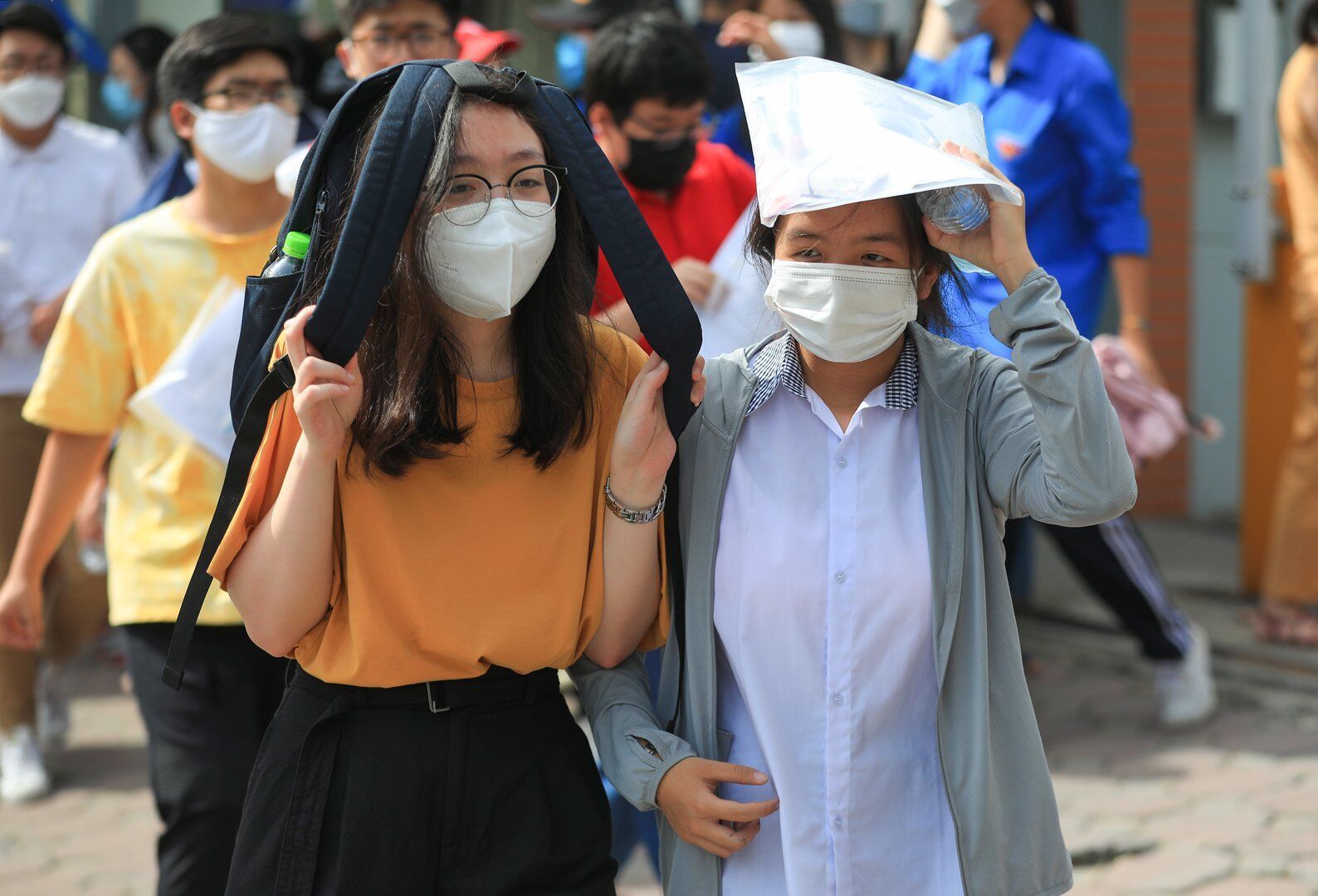 Do trời nắng n&oacute;ng, nhiều th&iacute; sinh ra khỏi ph&ograve;ng thi với tư thế bịt k&iacute;n đầu đi vội v&atilde; về ph&iacute;a cổng trường để ra về.