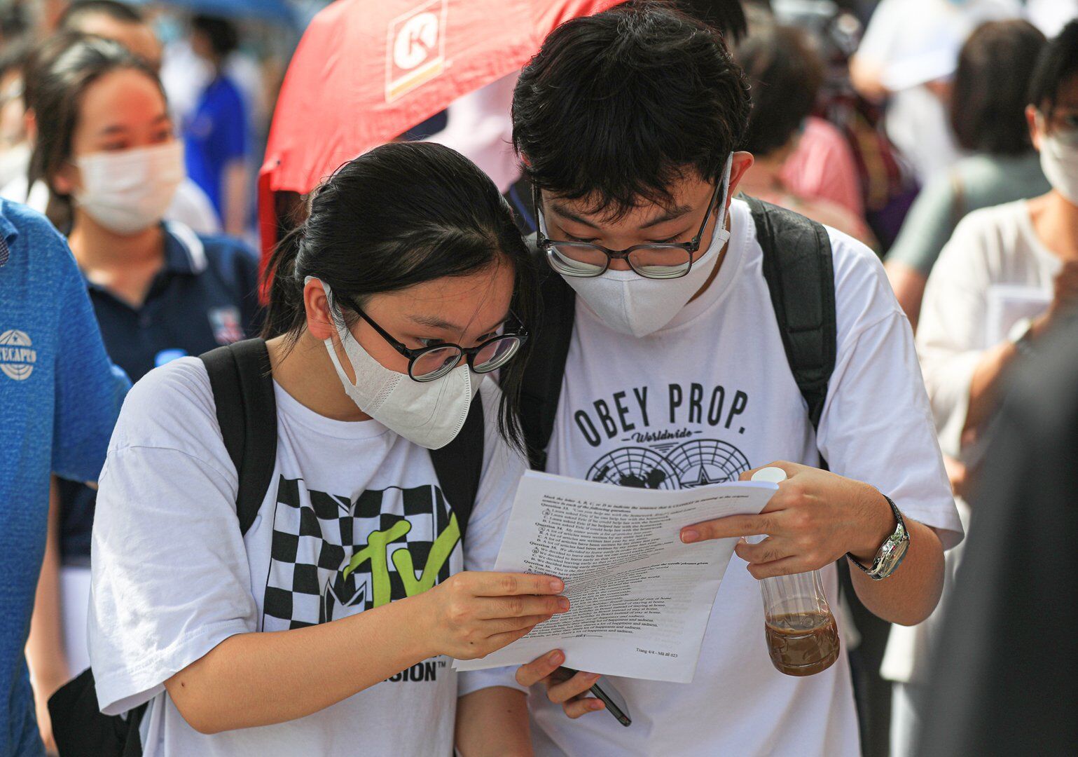 Kết th&uacute;c giờ thi nhưng một số th&iacute; sinh vẫn n&aacute;n lại ph&iacute;a trước cổng trường để b&agrave;n luận đ&aacute;p &aacute;n.