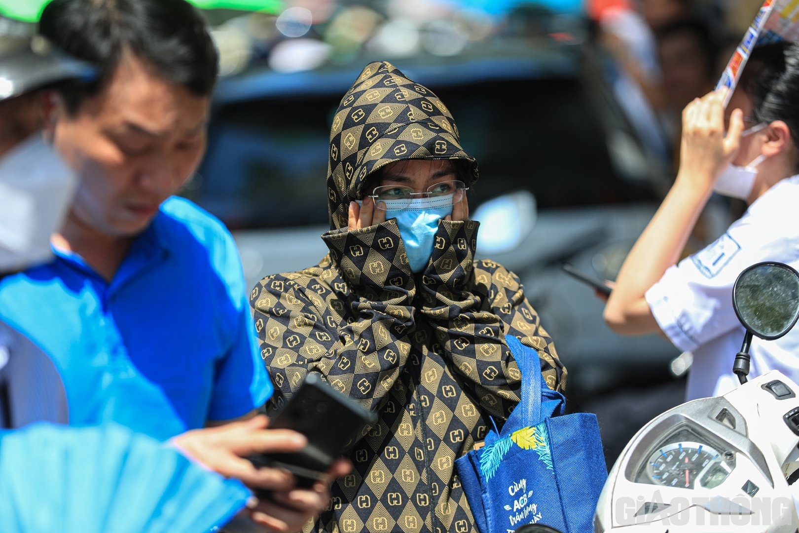 Nhiều người lựa chọn cho m&igrave;nh những trang phục k&iacute;n m&iacute;t để chống lại c&aacute;i nắng gay gắt khi đợi đ&oacute;n th&iacute; sinh.