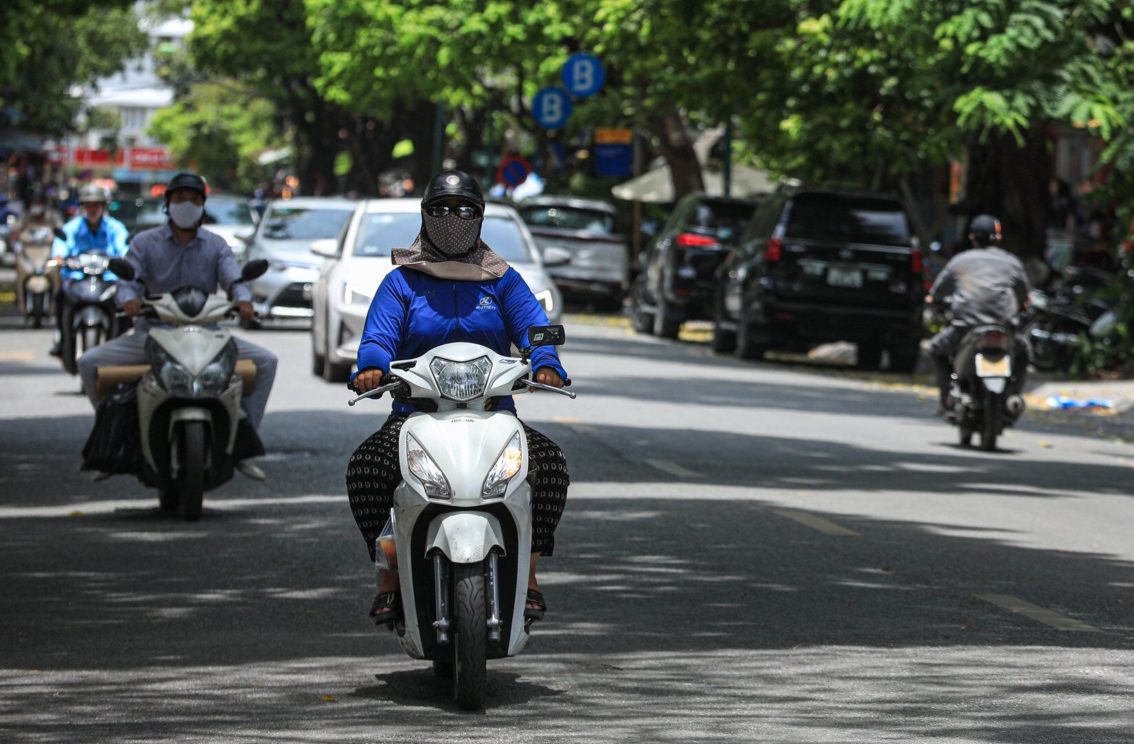Đa phần những người di chuyển bằng xe m&aacute;y tr&ecirc;n đường đều phải ch&ugrave;m &aacute;o, quần k&iacute;n người để tr&aacute;nh c&aacute;i nắng gay gắt.