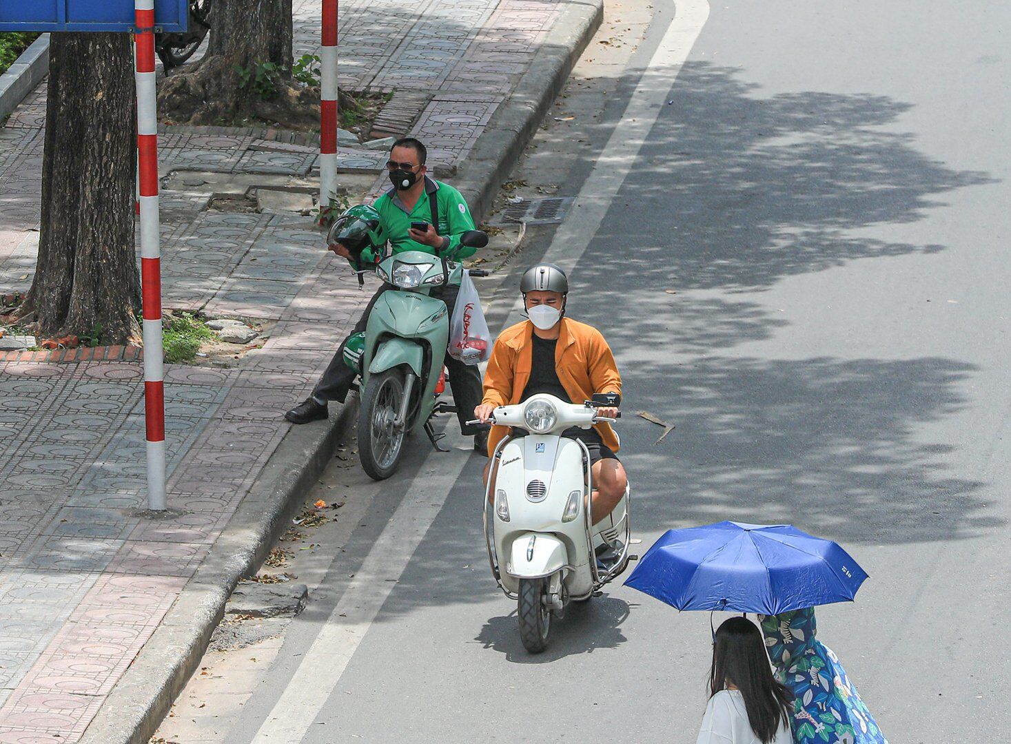 Một số người tham gia giao th&ocirc;ng dừng đ&egrave;n đỏ đ&atilde; chọn những điểm c&oacute; b&oacute;ng c&acirc;y để dừng.