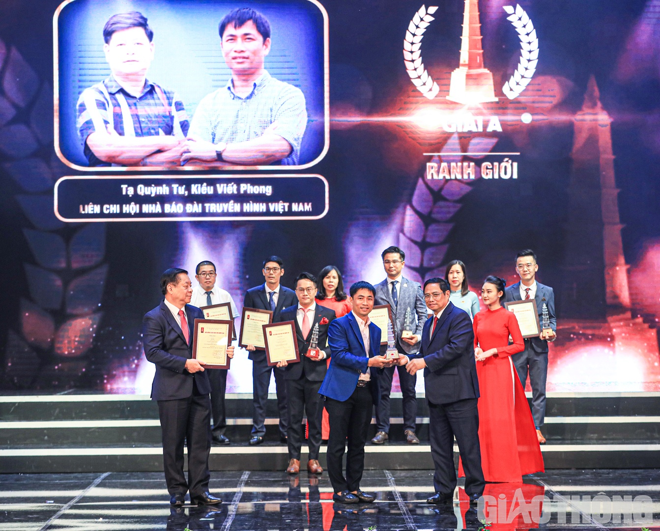 Thủ tướng Ch&iacute;nh phủ Phạm Minh Ch&iacute;nh v&agrave; Trưởng Ban Tuy&ecirc;n gi&aacute;o Trung ương Nguyễn Trọng Nghĩa trao chứng nhận cho đại diện t&aacute;c giả, nh&oacute;m t&aacute;c giả đạt giải A.