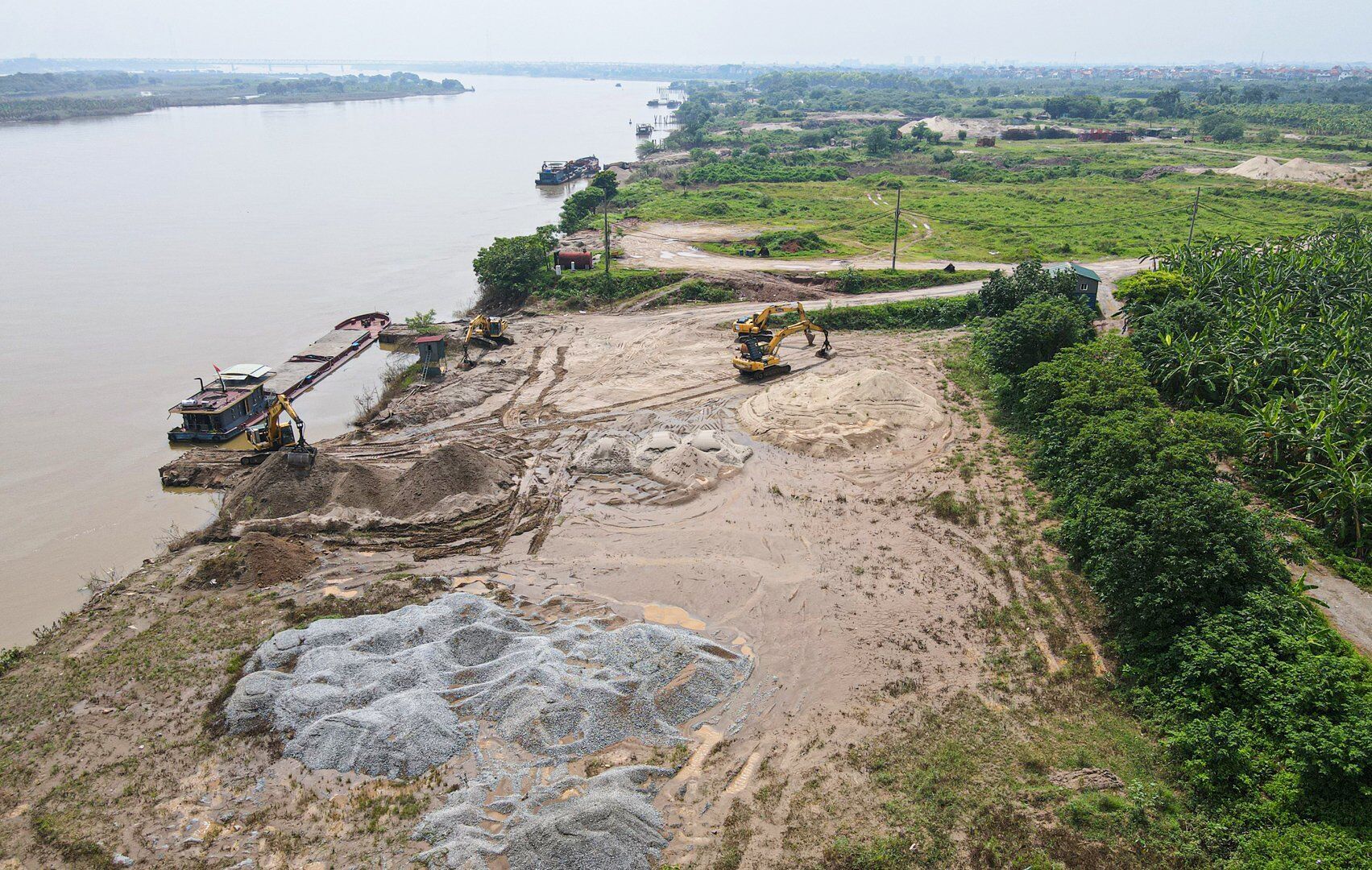 Rất nhiều m&aacute;y x&uacute;c được tập kết tại đ&acirc;y để sẵn s&agrave;ng hoạt động sang tải c&aacute;t, sỏi l&ecirc;n b&atilde;i tập kết vật liệu.