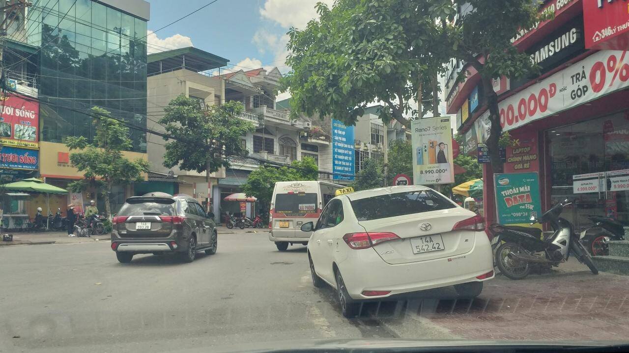 Một xe taxi c&ograve;n đỗ "ghếch ch&acirc;n" l&ecirc;n vỉa h&egrave;, kề đ&oacute; l&agrave; nhiều xe vận tải h&agrave;nh kh&aacute;ch đỗ cho&aacute;n hết phần đường rẽ v&agrave;o Tỉnh lộ 334 để đ&oacute;n, trả kh&aacute;ch khiến một l&agrave;n phương tiện từ ph&iacute;a trong ra bị chặn lại.