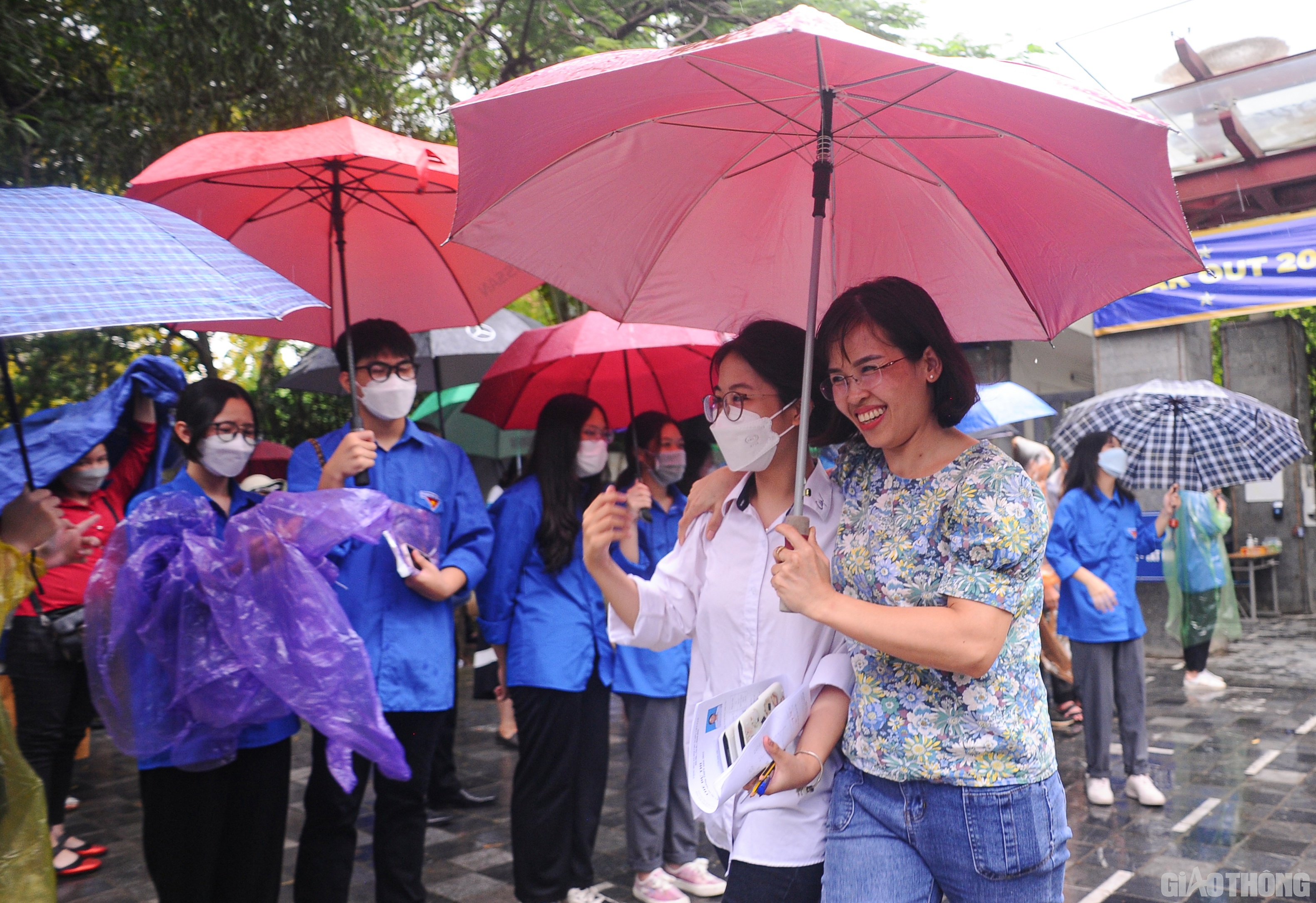 C&aacute;c phụ huynh cũng nhanh ch&oacute;ng tiến v&agrave;o s&aacute;t cổng trường che &ocirc; cho con.