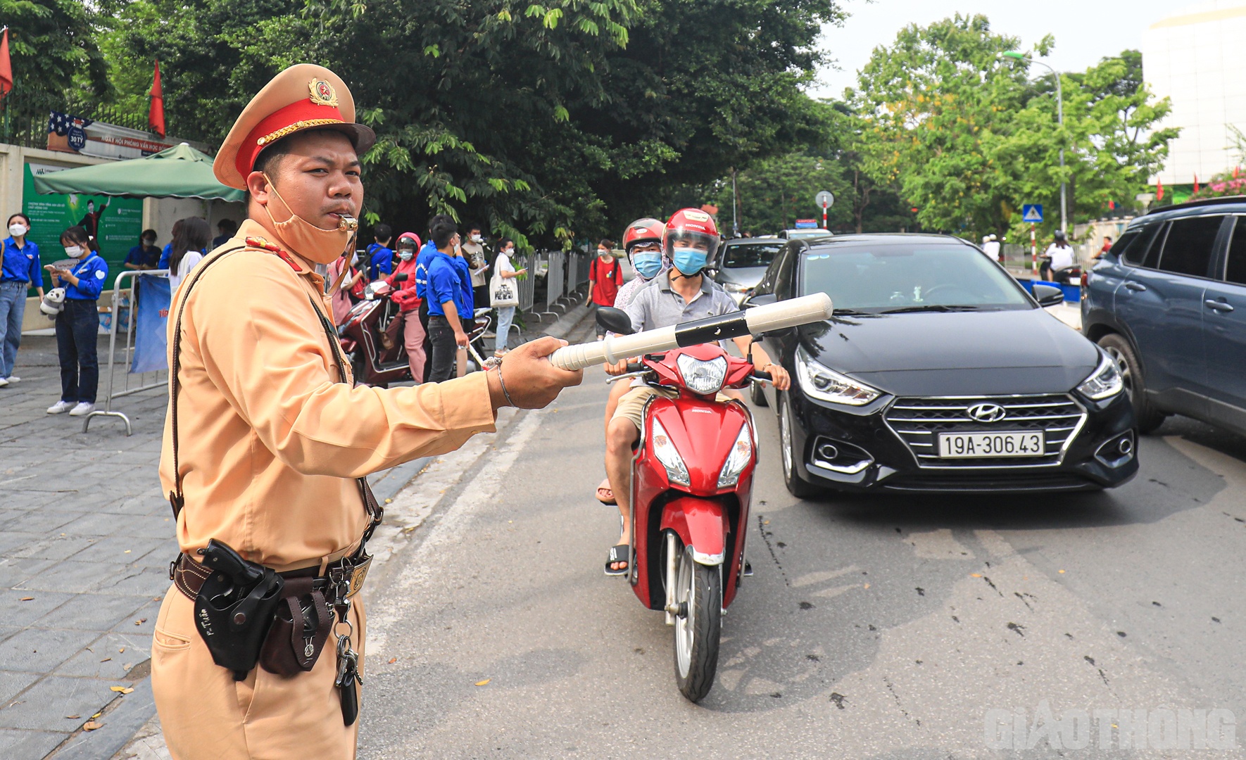 B&ecirc;n cạnh đ&oacute; l&agrave; h&igrave;nh ảnh những chiến sĩ CSGT đội nắng, dầm mưa điều tiết, ph&acirc;n l&agrave;n giao th&ocirc;ng cho phụ huynh v&agrave; sĩ tử.