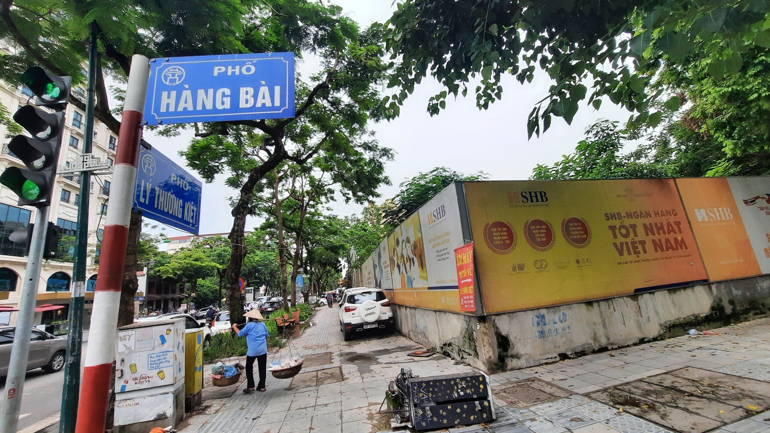 Bên ngoài là tường rào bao quanh, cùng với đó là biển quảng cáo của Ngân hàng SHB.