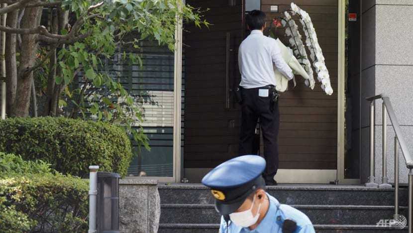 Nhân viên đưa lẵng hoa viếng ông Abe Shinzo v&agrave;o b&ecirc;n trong nh&agrave;. Ảnh - AFP