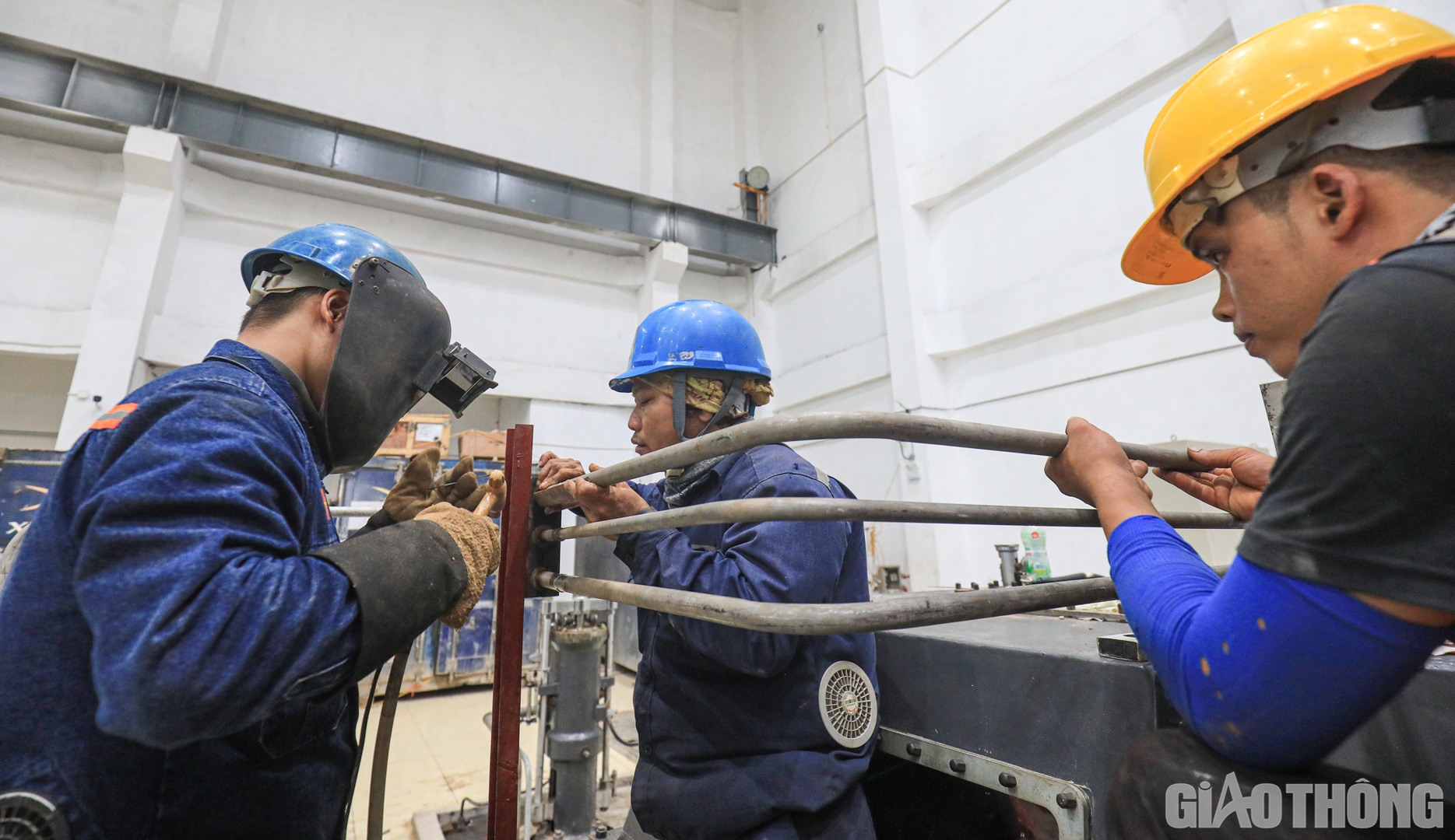 Nh&oacute;m c&ocirc;ng nh&acirc;n đang khẩn trương lắp ống dẫn dầu cho tua bin.
