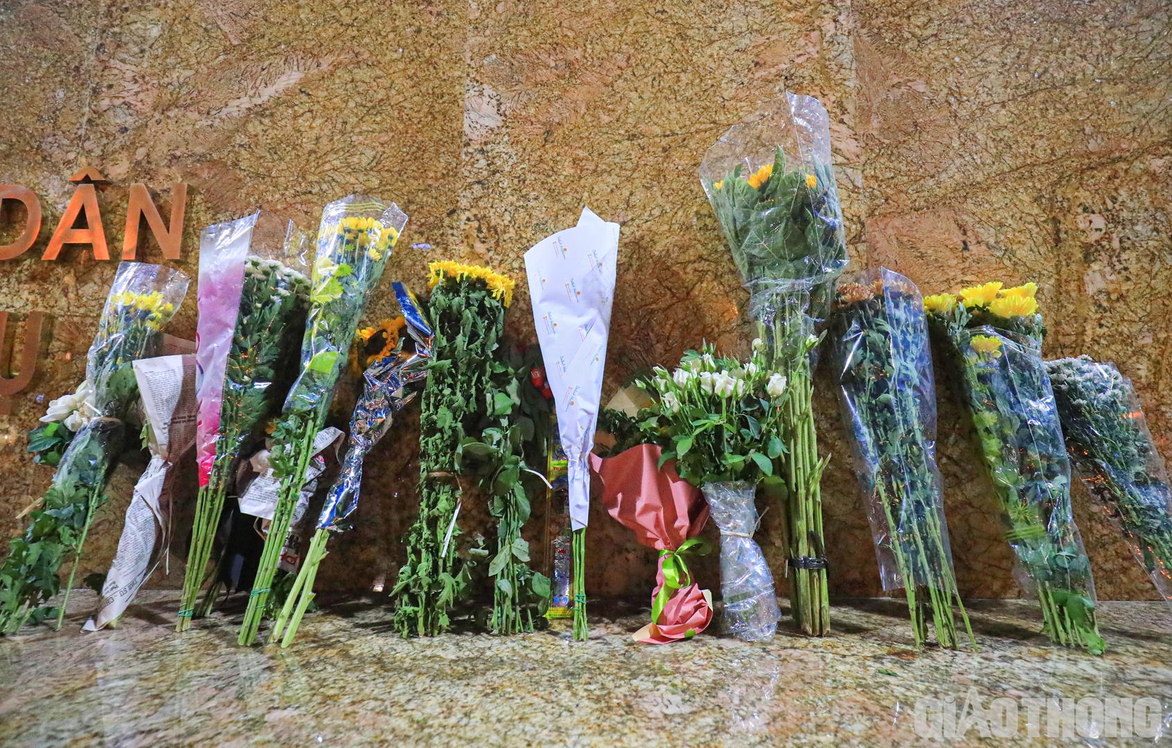 Những b&oacute; hoa tươi được đặt ngay ngắn ph&iacute;a trước tượng đ&agrave;i.