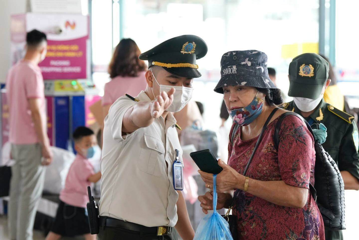 Nh&acirc;n vi&ecirc;n an ninh hướng dẫn cho một h&agrave;nh kh&aacute;ch lớn tuổi