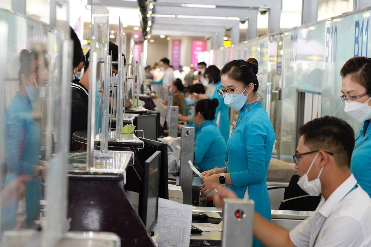 Nh&acirc;n vi&ecirc;n h&atilde;ng h&agrave;ng kh&ocirc;ng Vietnam Airlines căng m&igrave;nh l&agrave;m thủ tục check in cho h&agrave;nh kh&aacute;ch tại quầy