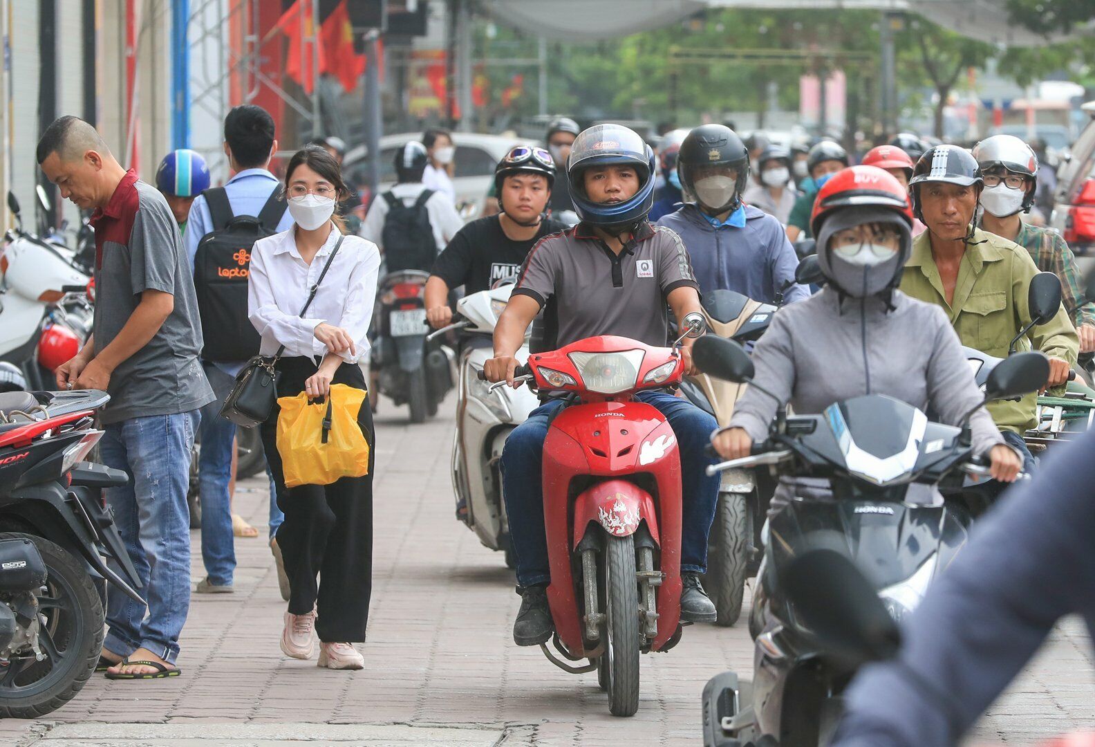 Tại đường Nguyễn Xiển, nhiều người đi xe m&aacute;y leo l&ecirc;n vỉa h&egrave; để đi nhanh hơn, lấn chiếm đường d&agrave;nh cho người đi bộ.