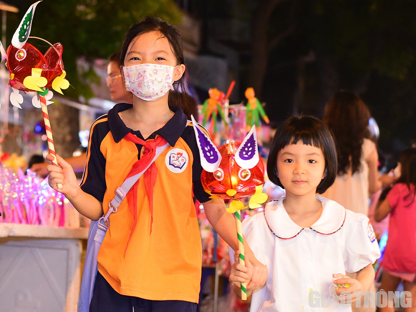 Hai em nhỏ th&iacute;ch th&uacute; cầm tr&ecirc;n tay m&oacute;n đồ chơi sặc sỡ.