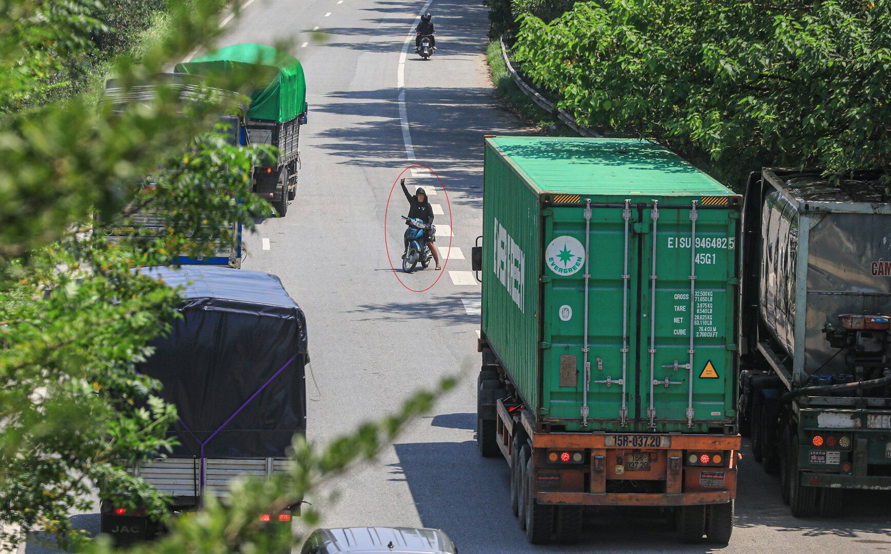 Chỉ trong v&ograve;ng chưa đầy 10 ph&uacute;t trưa 6/9, PV B&aacute;o Giao th&ocirc;ng ghi nhận, một người đ&agrave;n &ocirc;ng 3 lần đi xe m&aacute;y ngược chiều tr&ecirc;n Quốc lộ 18 rồi l&aacute;i xe 1 tay, tay c&ograve;n lại li&ecirc;n tục vẫy, với gọi những chiếc xe tải chạy tr&ecirc;n đường đi v&agrave;o qu&aacute;n m&igrave;nh.